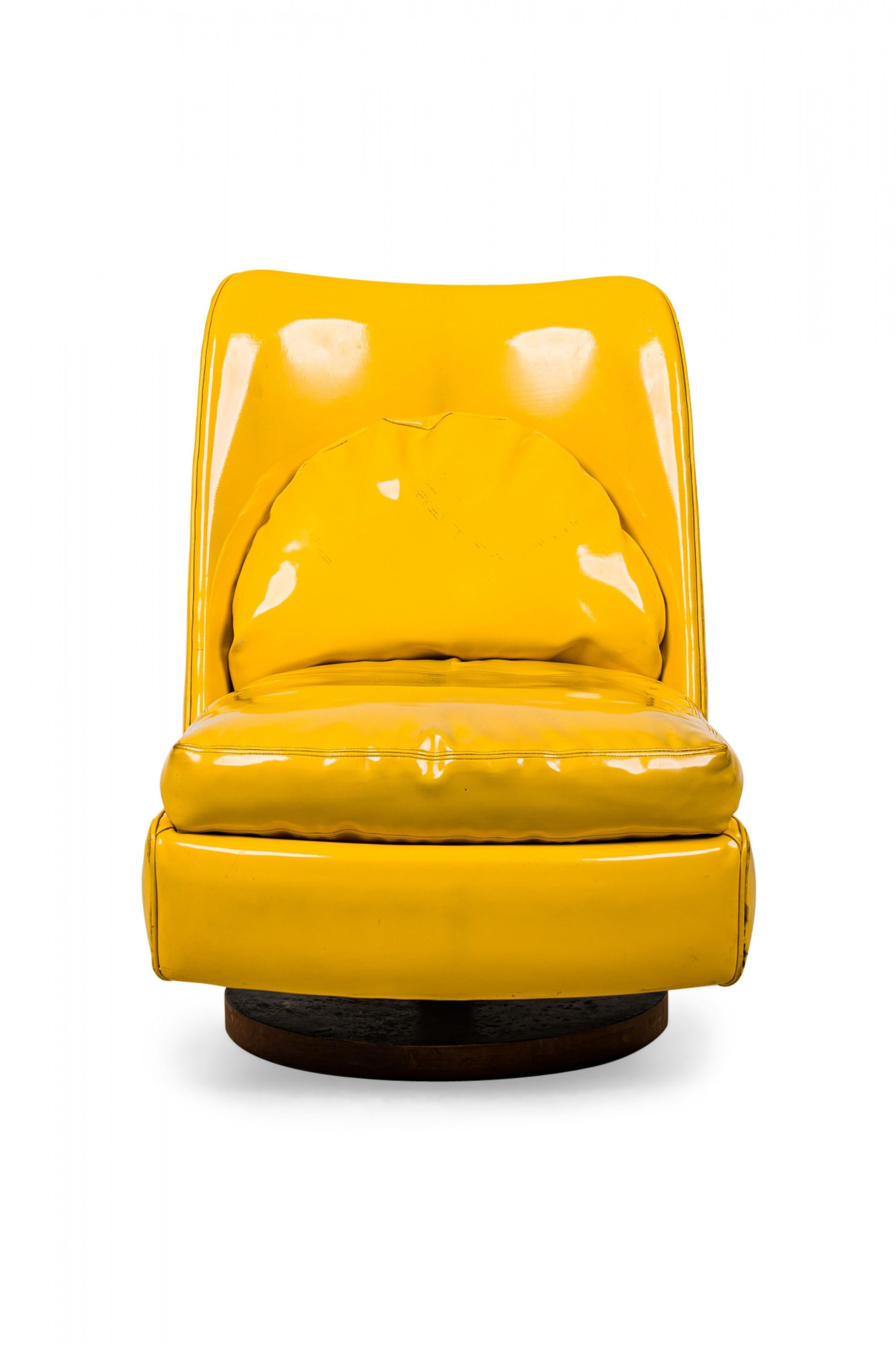 Chaise d'appoint pivotante et basculante de style américain du milieu du siècle dernier. Revêtement en cuir verni jaune vif et coussin de dossier semi-circulaire incorporé. (MILO BAUGHMAN)
