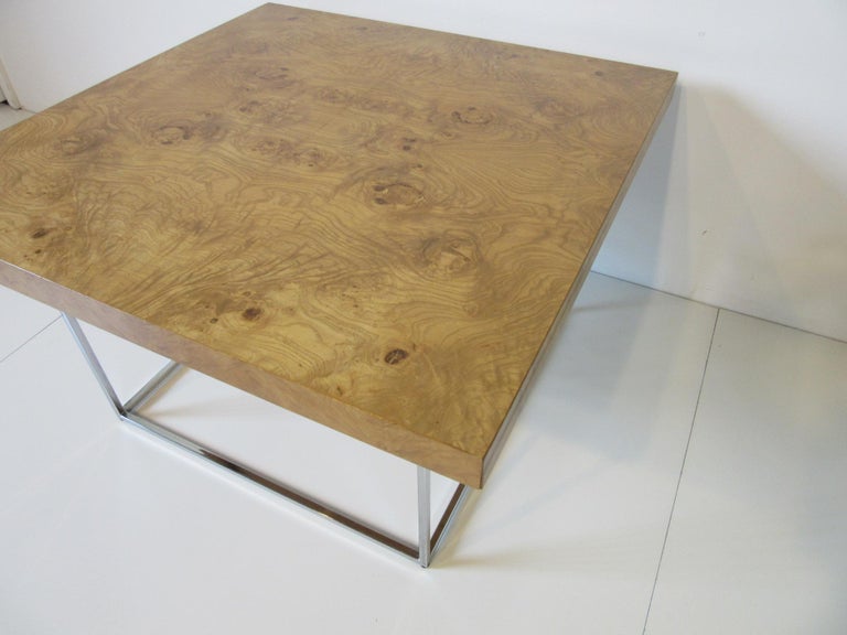 A beautiful burl olive wood coffee table with square chromed tubed base, this table makes a statement and will provide years of enjoyment. Manufactured in the style of Thayer Coggin Furniture Company.