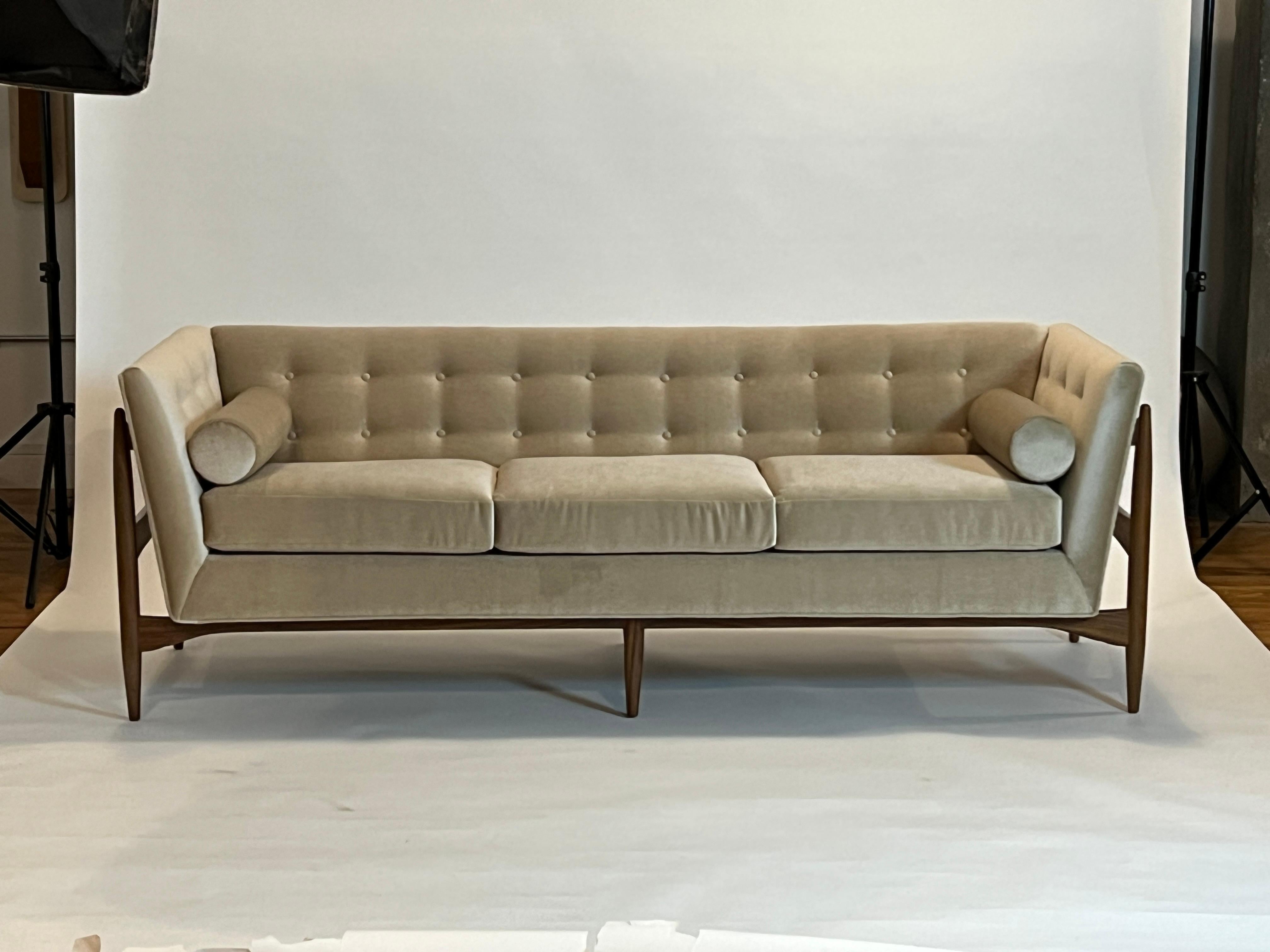 Das von Thayer Coggin hergestellte und von Milo Baughman 1959 entworfene Sofa Button Up ist ein zeitloses Sofa der Jahrhundertmitte. Das Sofa Button Up zeichnet sich durch Knopftufting und ein Gestell aus massivem Walnussholz aus, das aus jedem