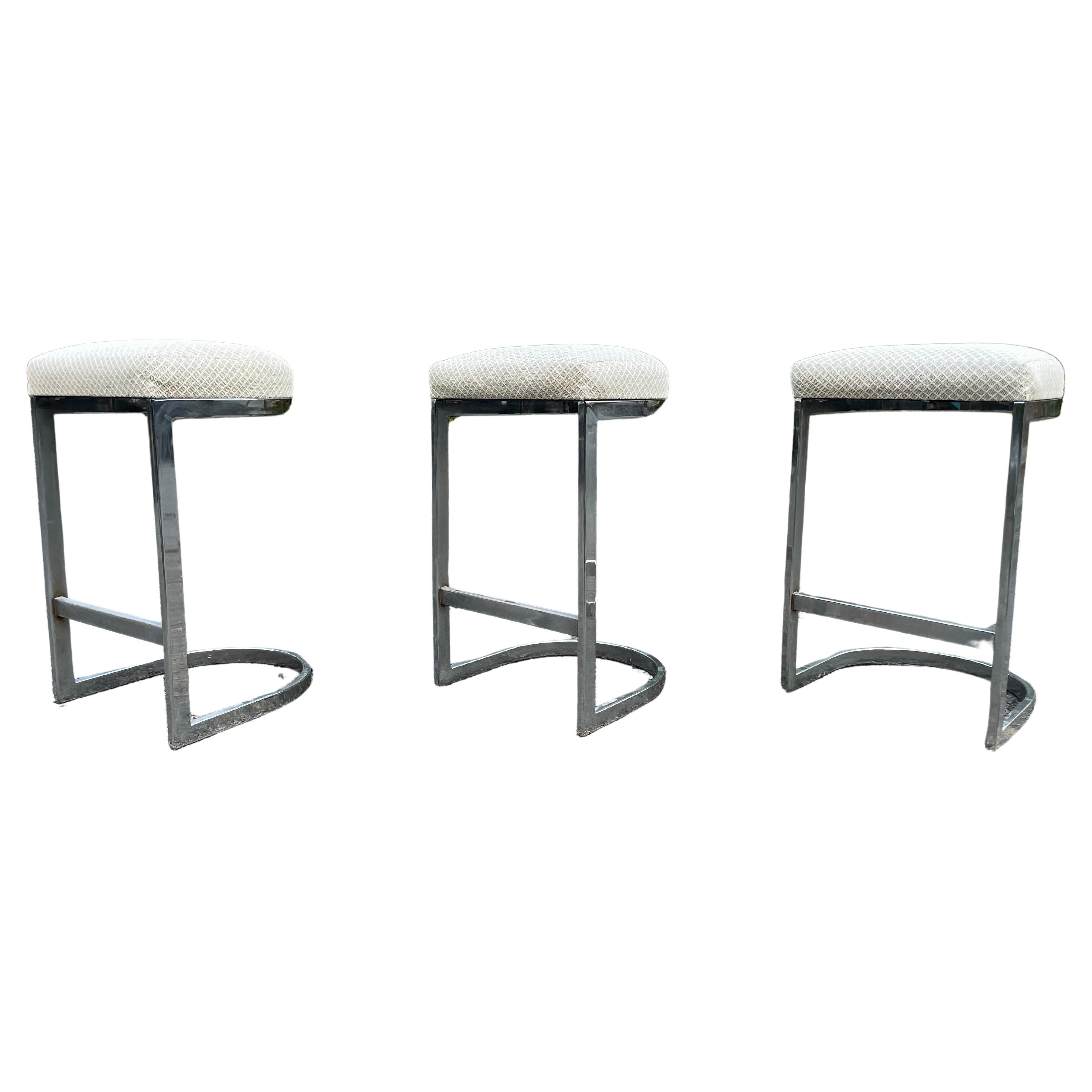 Set of three sculptural chrome cantilever bar stools by Milo Baughman. 

Great lines on these bar stools. Clean and simple design. The chrome really plays well off the blush.

Chrome flat bar bases and the fabric are both in very good vintage