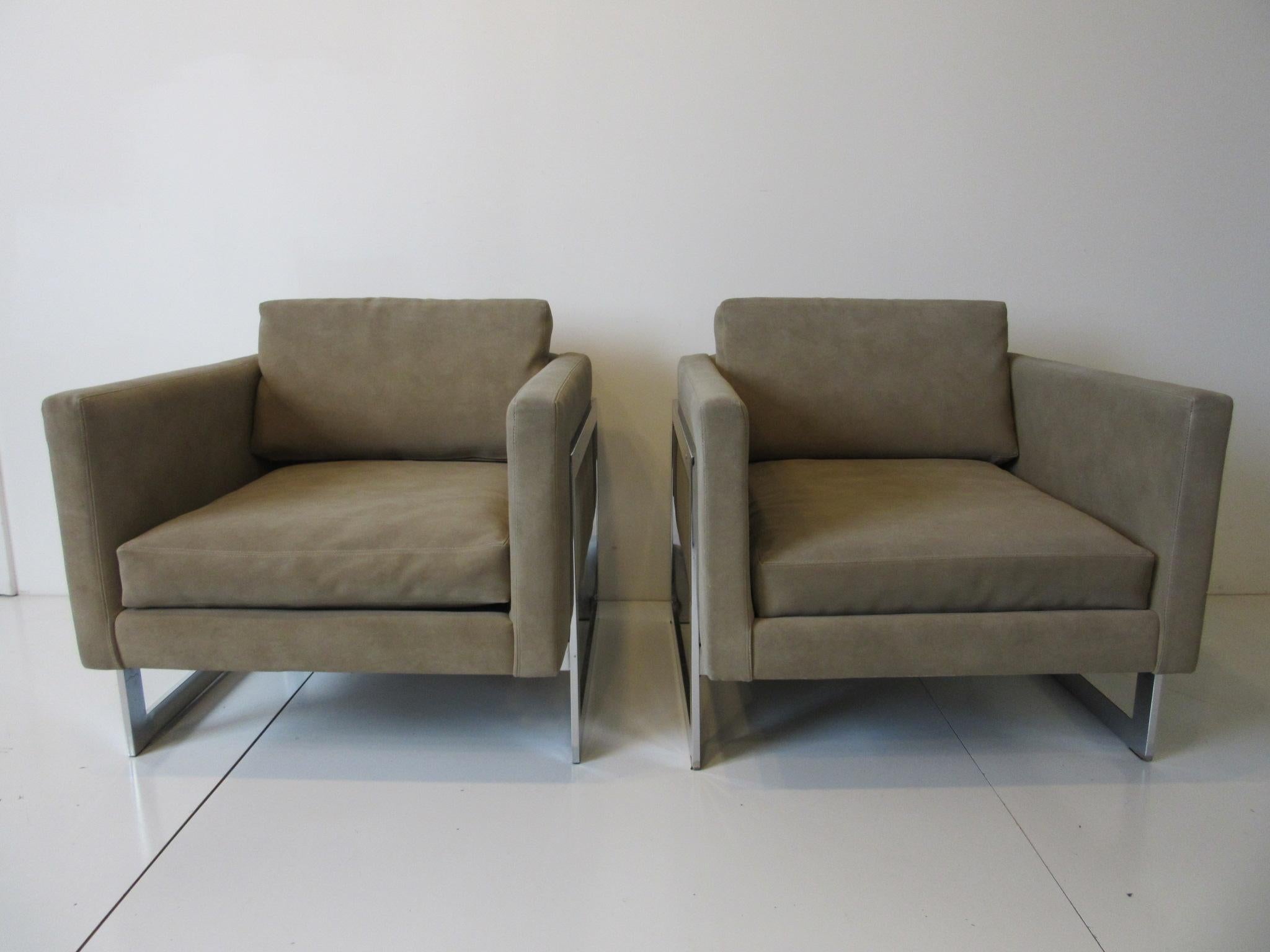 A pair of cantilevered cube lounge chairs with loose back and bottom cushions in a dark sandy taupe ultra suede. Sitting on polished steel chromed frames and retaining the manufactures paper label by the Thayer Coggin furniture company, these fine