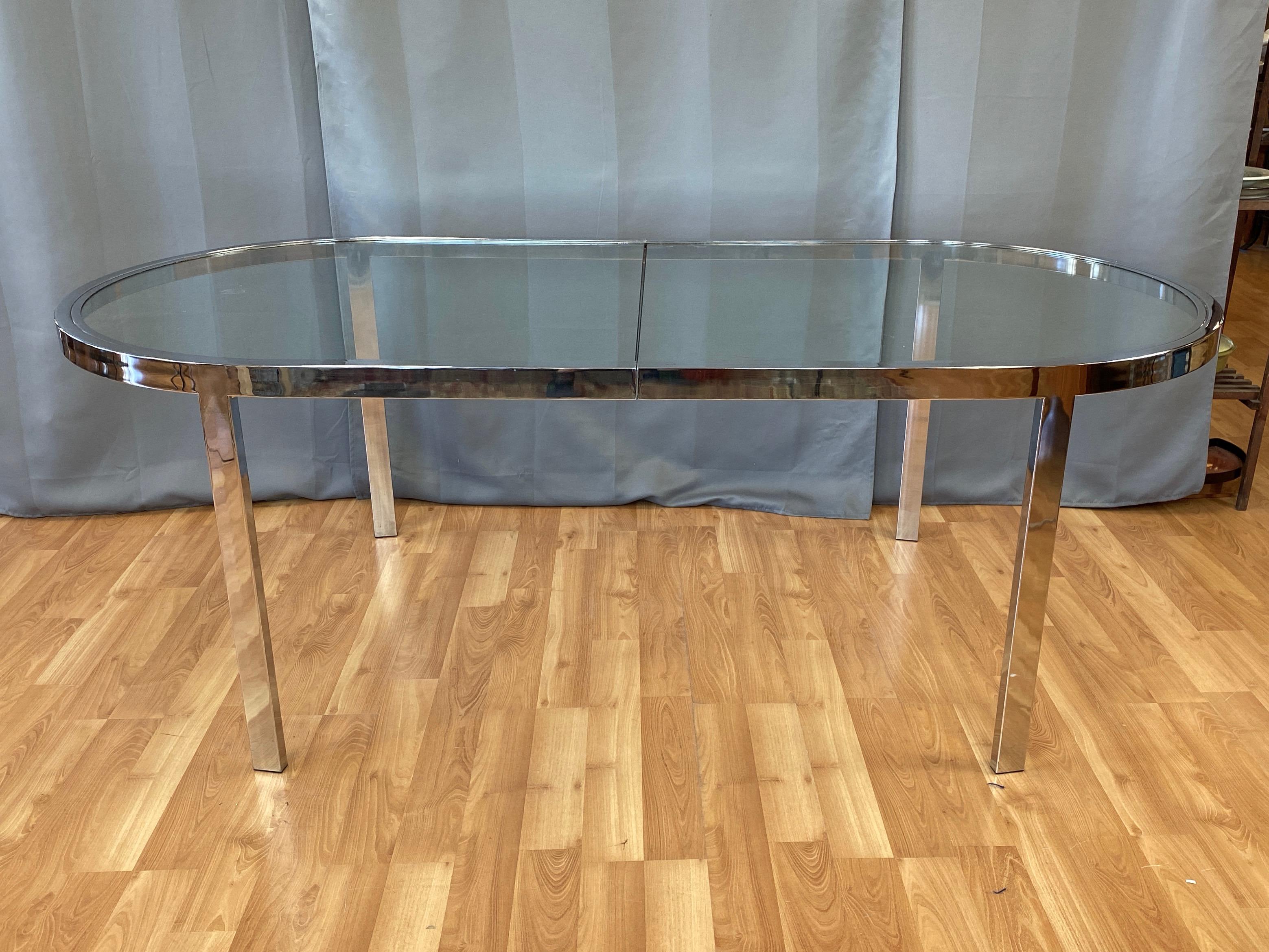 A super sleek 1970s chrome and glass dining table by Milo Baughman, master of American Mid-Century Modern Minimalism. 

Clean-lined racetrack frame and legs of flat bar-like chromed steel meet seamlessly at geometric points that handsomely bridge