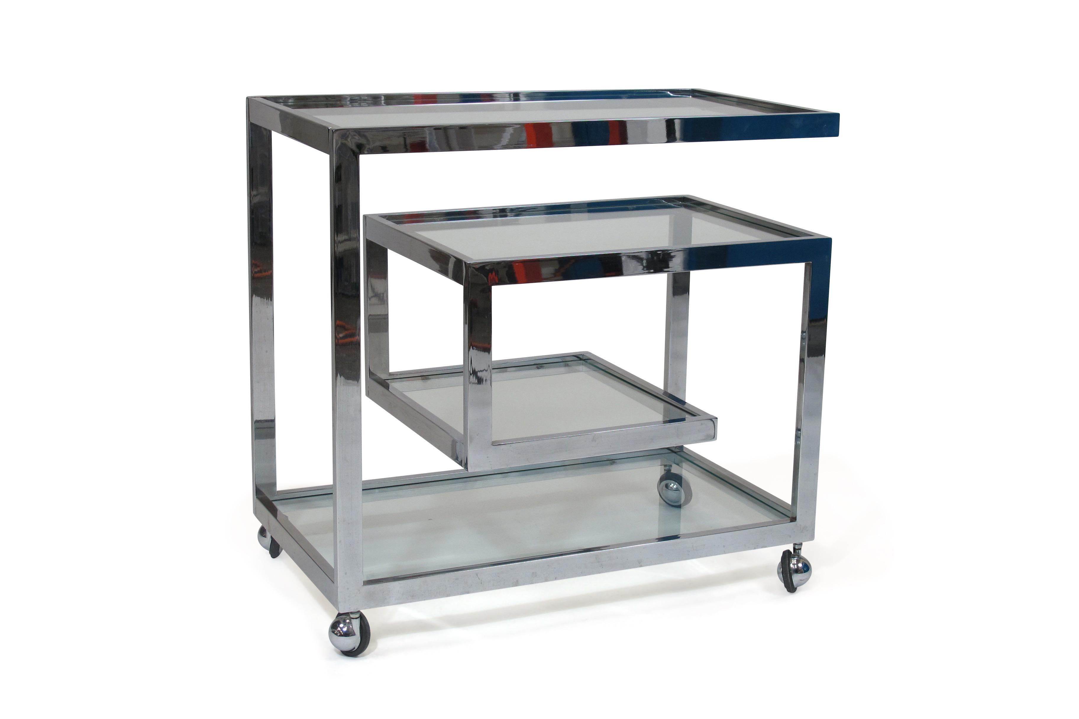 Midcentury chrome bar cart attributed to Arthur Umanoff for Dillingham circa 1970, United States. Bar cart constructed of chrome with glass shelves, and matching castors.