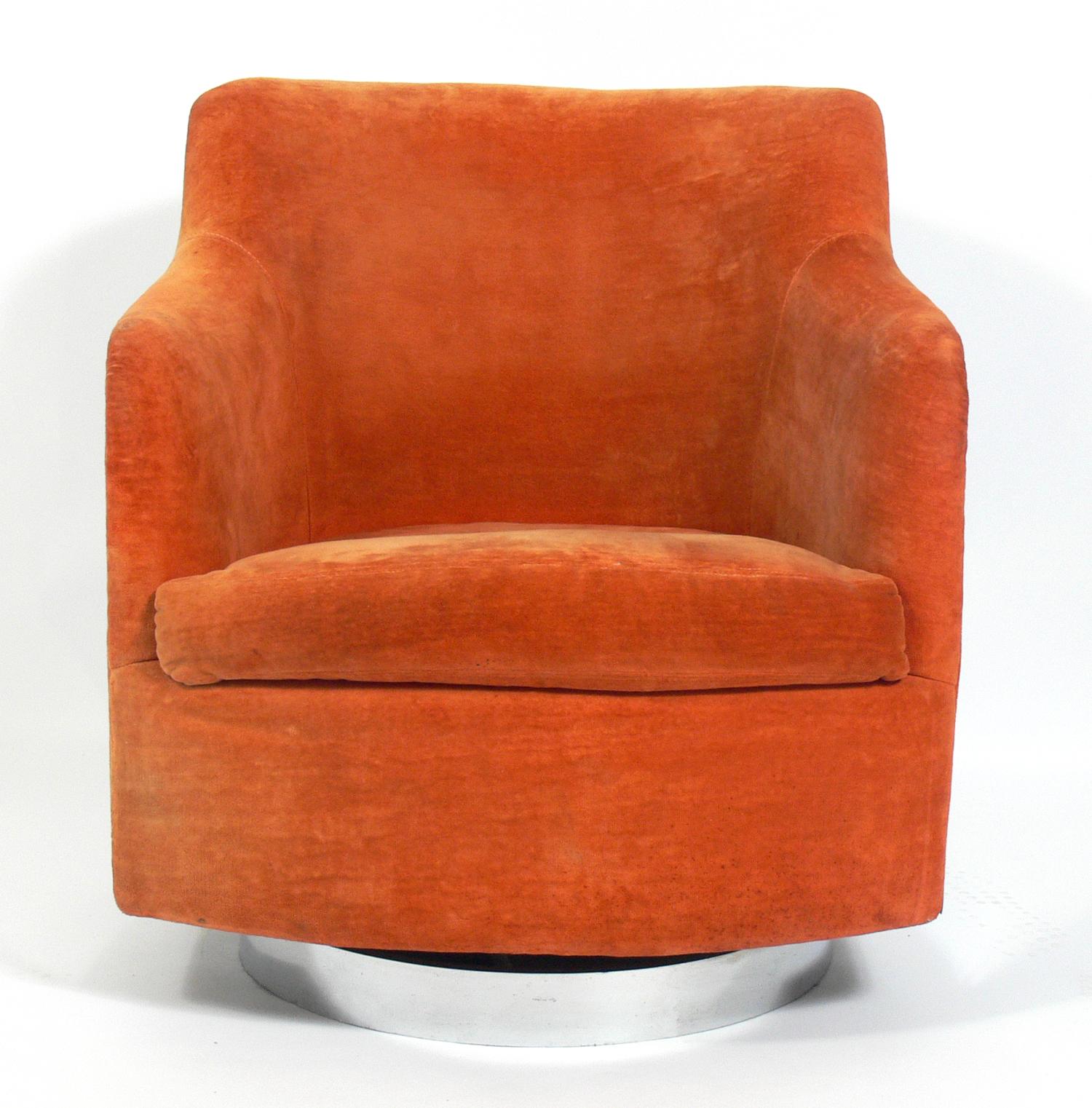 Curvaceous chrome swivel chair, designed by Milo Baughman, American, circa 1960s. Chrome has been hand polished. Retains original orange velvet style fabric. We can reupholster it for you in your fabric for an additional $400 if you prefer.