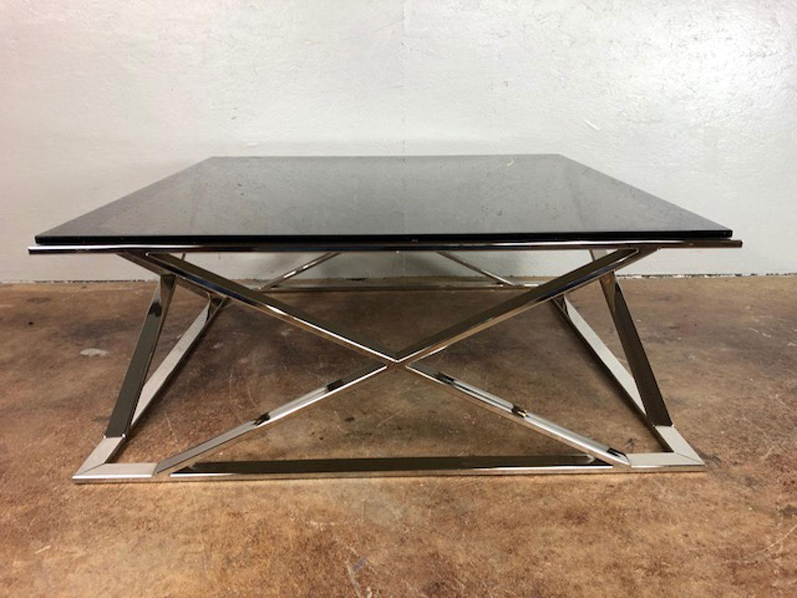 Milo Baughman polished stainless steel and glass coffee table. Superb look. Polished stainless is in very good condition. Original smoked glass top is fully intact. The glass has one postage stamp sized imperfection 