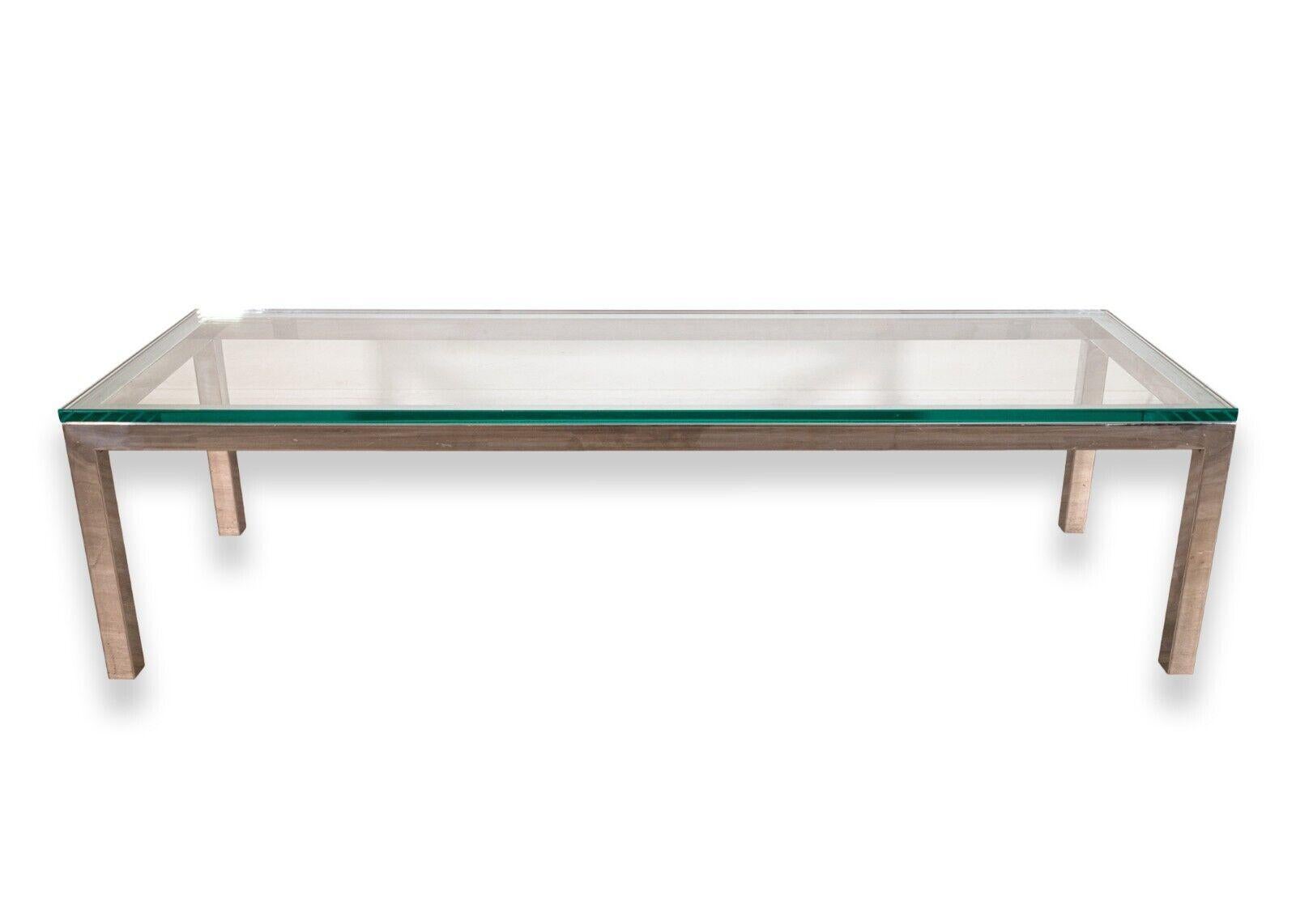 A Milo Baughman contemporary modern rectangular chrome and glass coffee table. A beautiful coffee table featuring a sleek, rectangular chrome frame, and a matching thick glass table top. This piece is in very good condition. It measures 16 in tall,