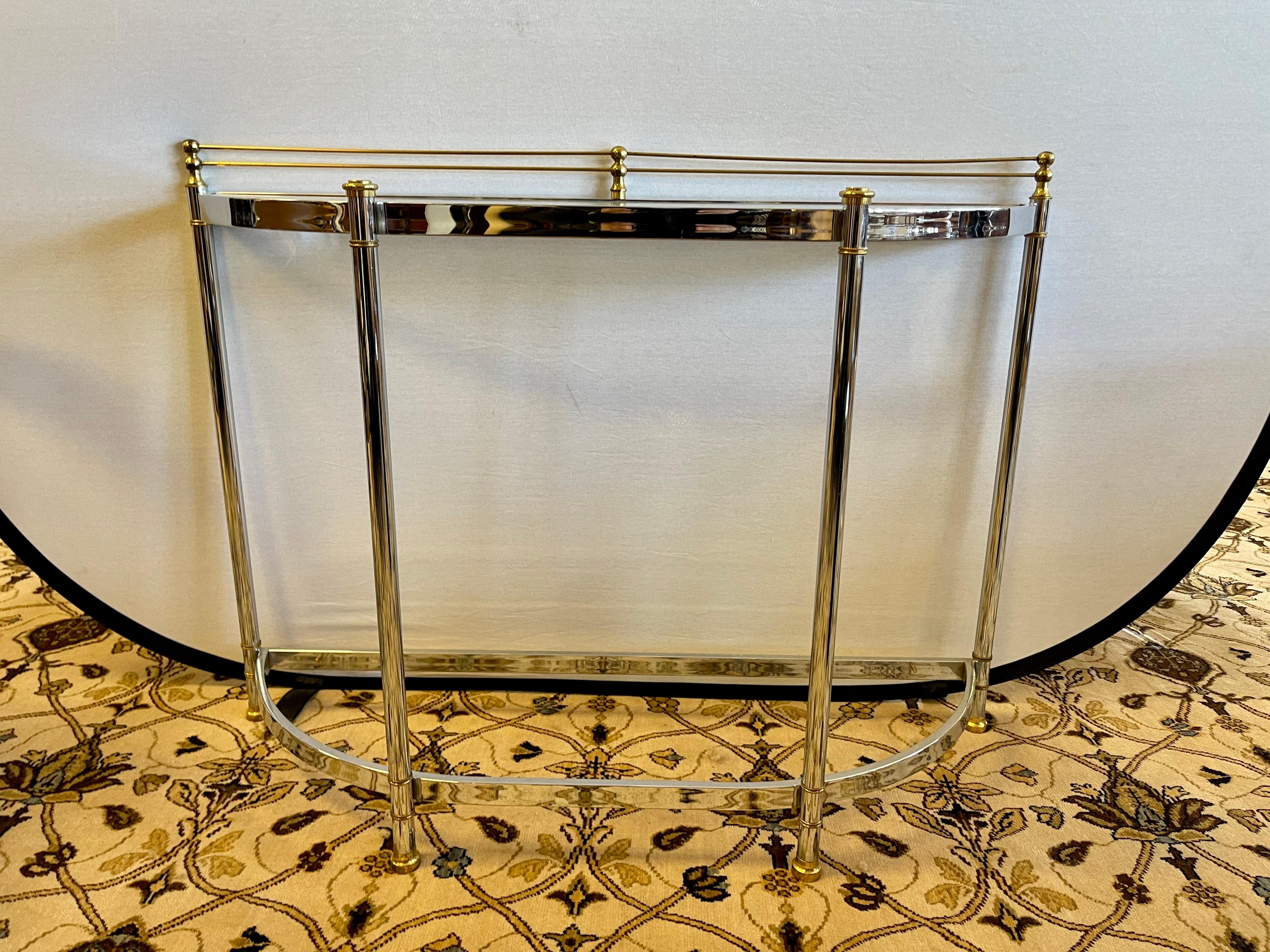 Magnificent Milo Baughman glass top with chrome base demilune table with brass accents.
Sculptural base makes this piece look like a sculpture. Nothing short of gorgeous. Glass top at top but note no glass on bottom. Iconic mid century classic.