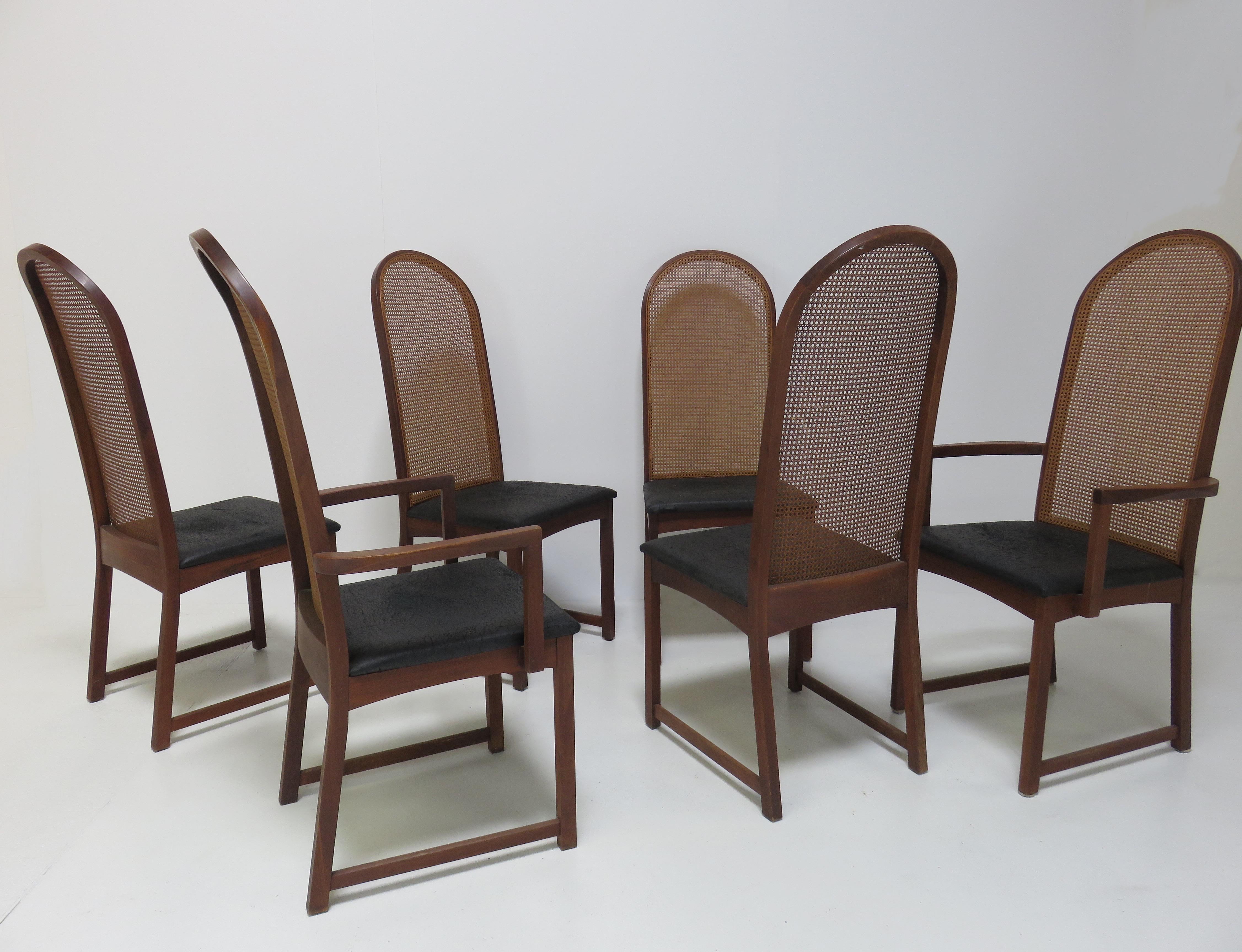A set of six dining chairs by Milo Baughman. Comprising four side chairs and two armchairs, each with cane backs and black vinyl seats with mahogany frames.