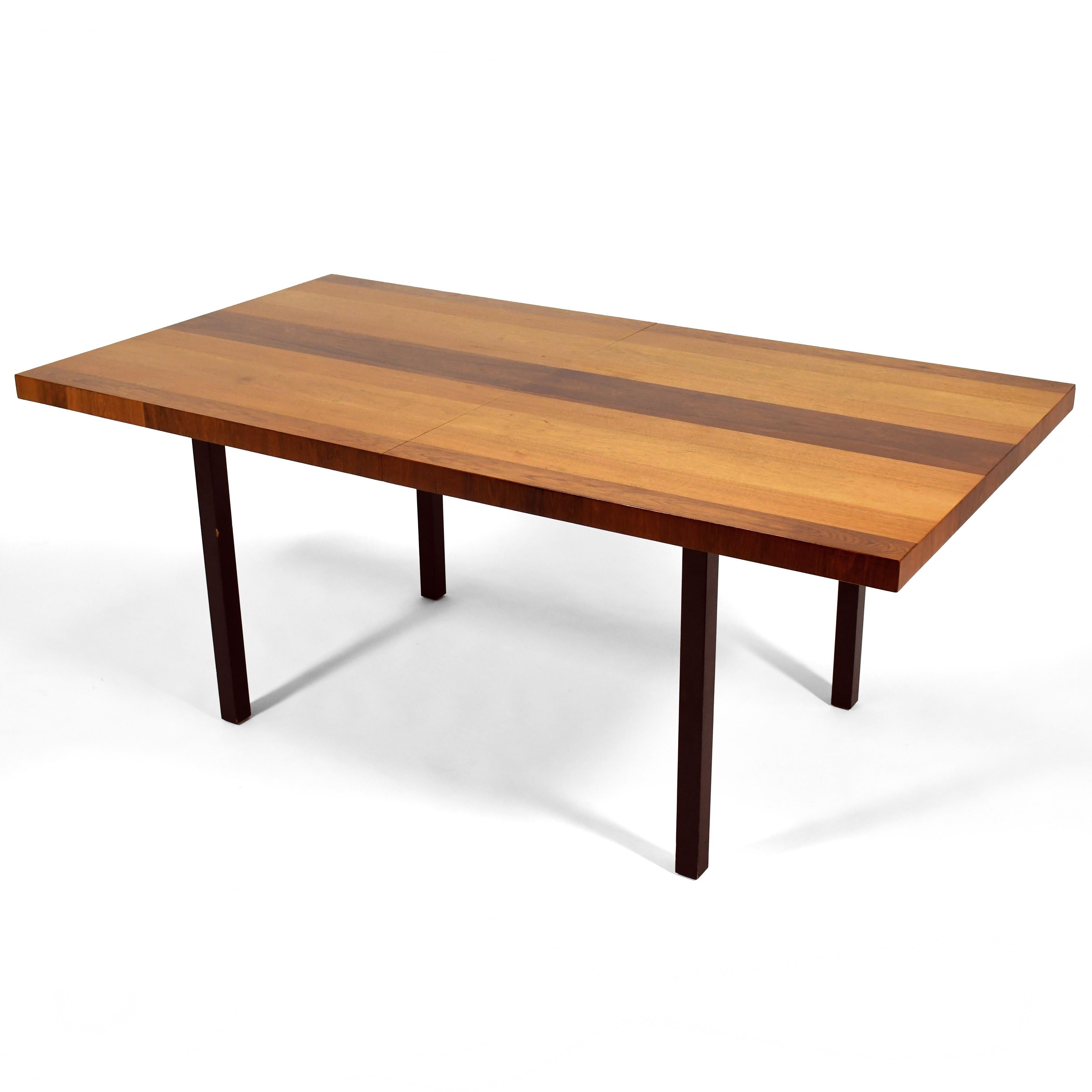 Cette table à manger classique du milieu du siècle dernier, conçue par Milo Baughman pour Directional, adopte une forme rectiligne simple et l'habille de bandes de placages de bois mélangés. La table de 72