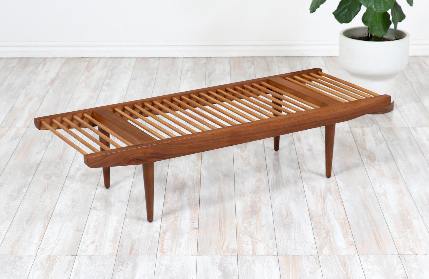 Elegant Californian Modern bench designed by Milo Baughman for Glenn of California in the United States circa 1950s. This beautiful dowel bench features a solid low profile frame and is comprised of a lovely contrast of walnut wood and oak wood,