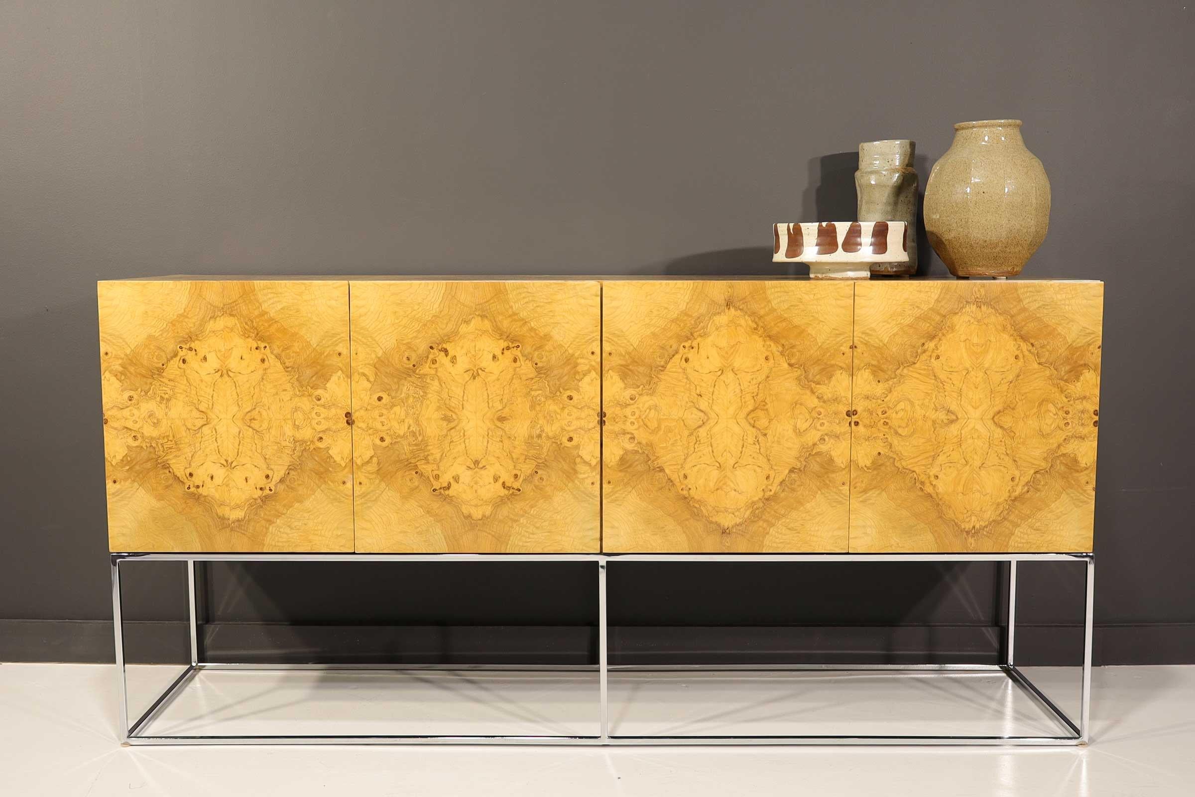 Dramatic and beautifully book matched burled olivewood sideboard by Milo Baughman for Thayer Coggin. The cabinet features four doors with two utility drawers on one side and shelving on the other side. The figured burl is amazing on this piece and