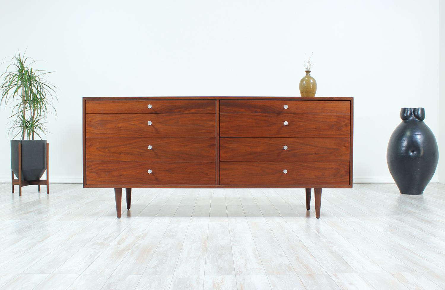 Mid Century modern dresser designed by Milo Baughman for Glenn of California in the United States circa 1950s. Newly refinished by our expert craftsmen, this spectacular eight-drawer dresser features a walnut-veneered case supported by tapered legs.