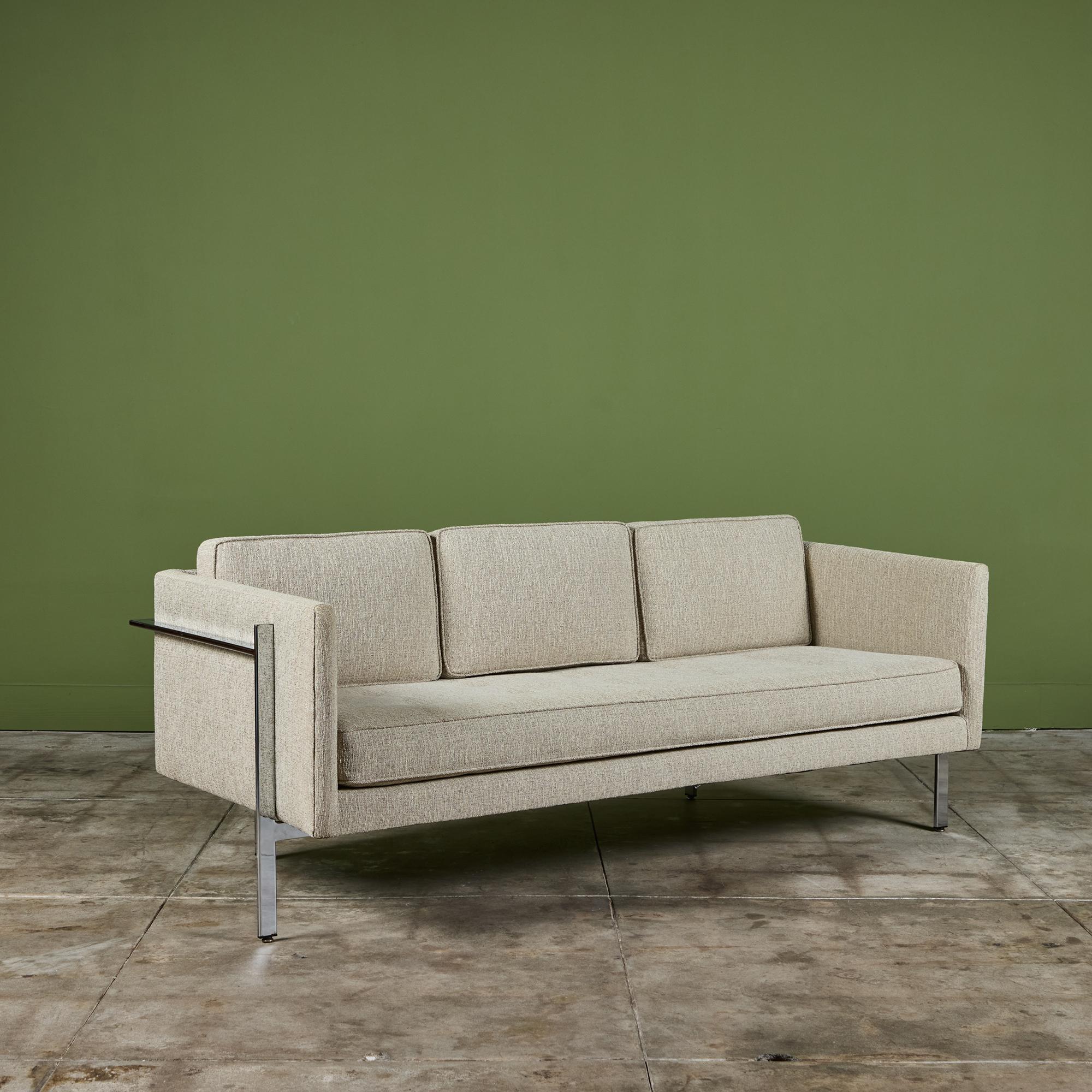 A classic sofa by Milo Baughman for Thayer Coggin. The sofa has been reupholstered in a knubby cream and brown textured fabric with tufting along the seat. The long, horizontal design appears to float above the ground on four chrome-plated