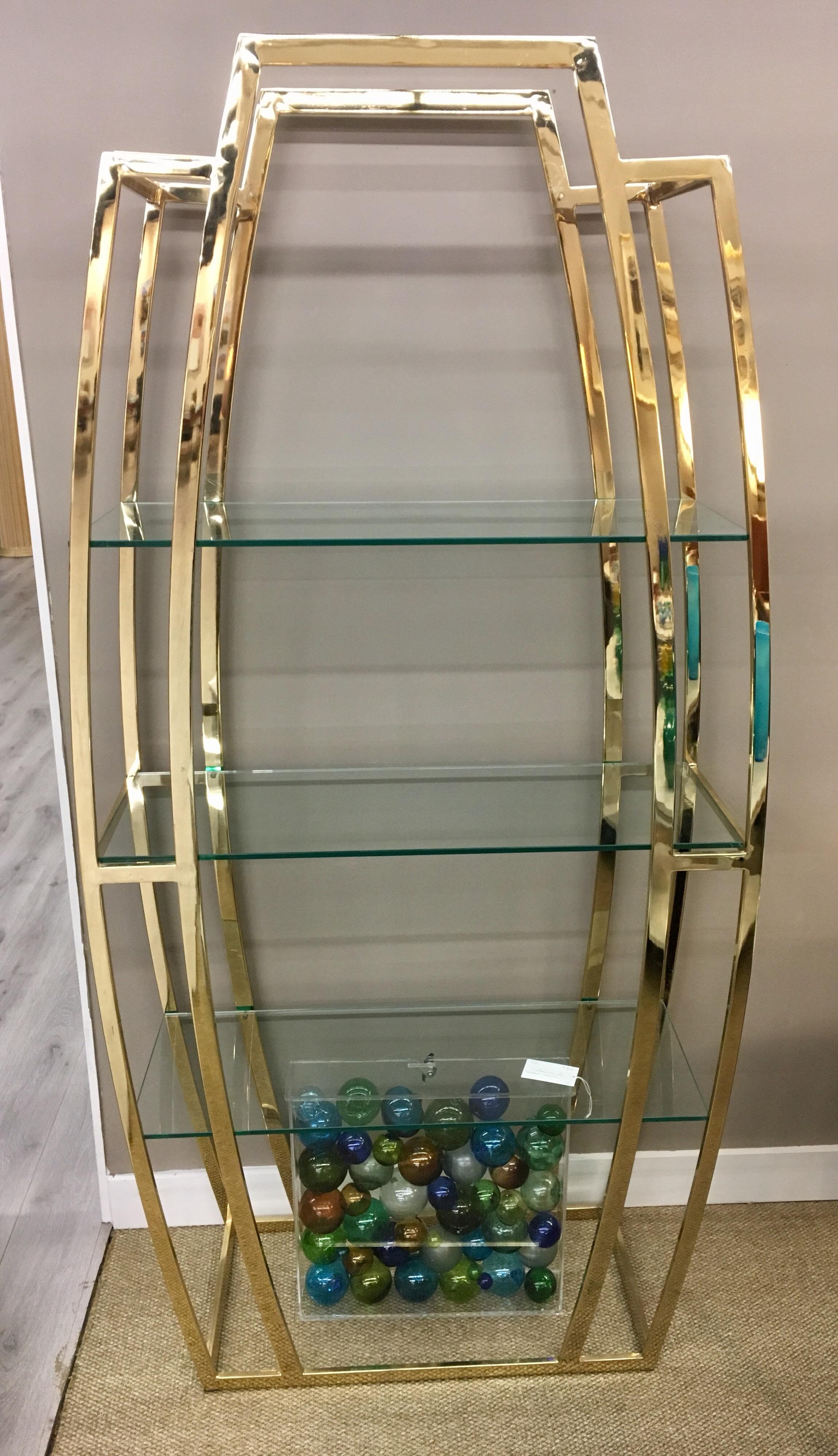 The epitome of midcentury grace is embodied in this Milo Baughman étagère which has three this glass shelves running across. Also to there is room for two more smaller glass shelves at very top and very bottom - your call.