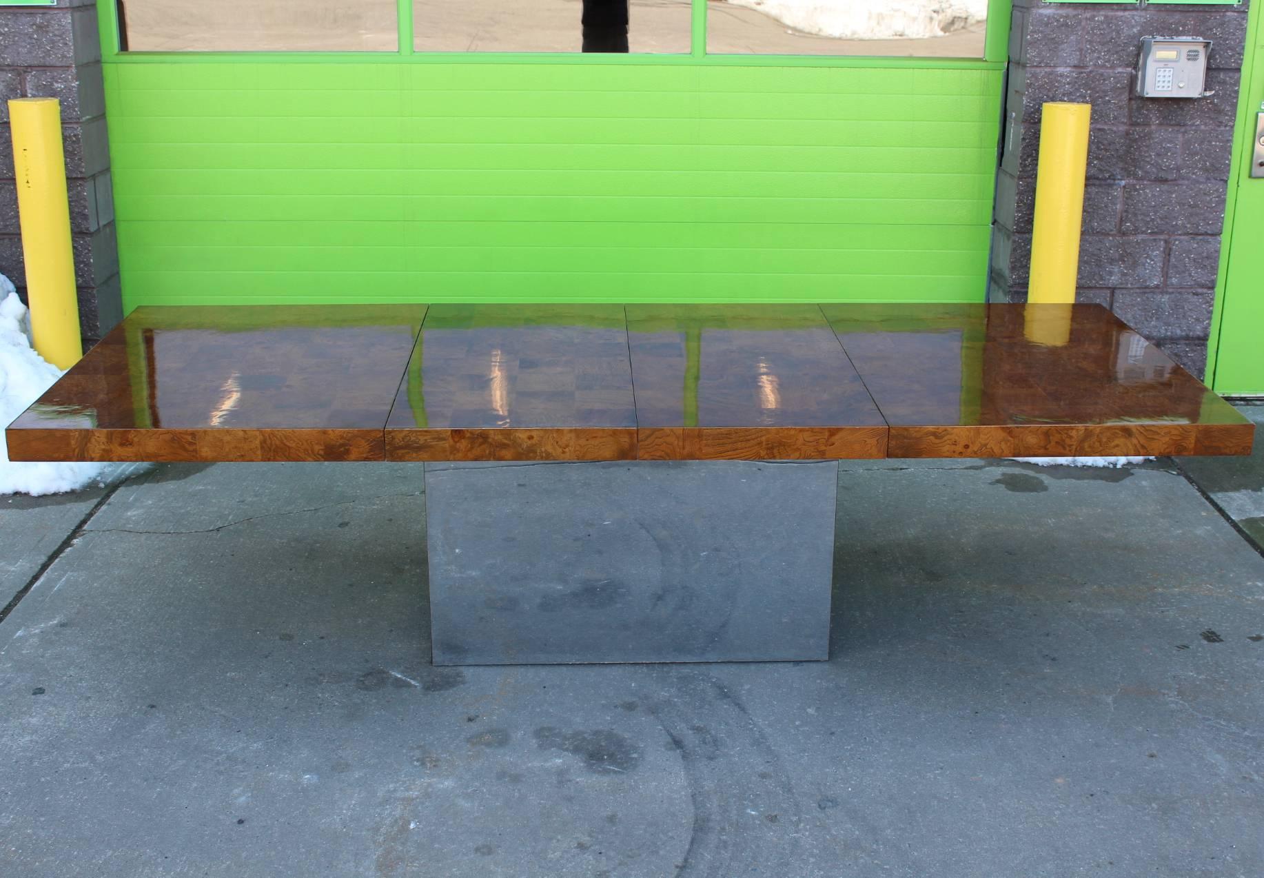 Milo Baughman expanding dining table with mosaic top of burl wood tiles. The piece stands on a rectangular chrome base. Crafted in the mid-20th century with two leaves at 22