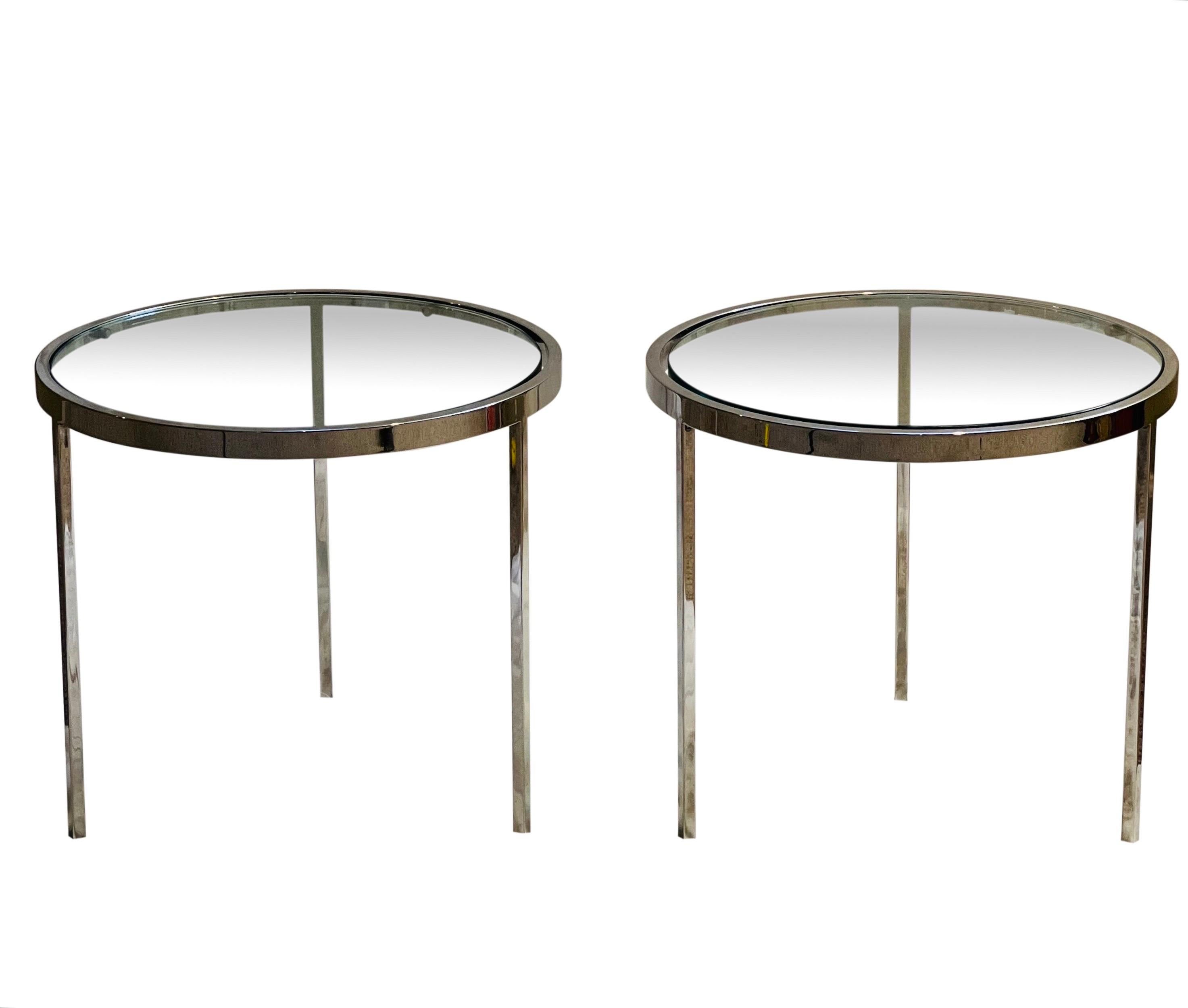 Pair of Milo Baughman low side tables. 

The pair features a flat bar, polished chrome frame, half inch thick glass and three straight legs. Sturdy tables with a modern and super clean design in very nice condition.