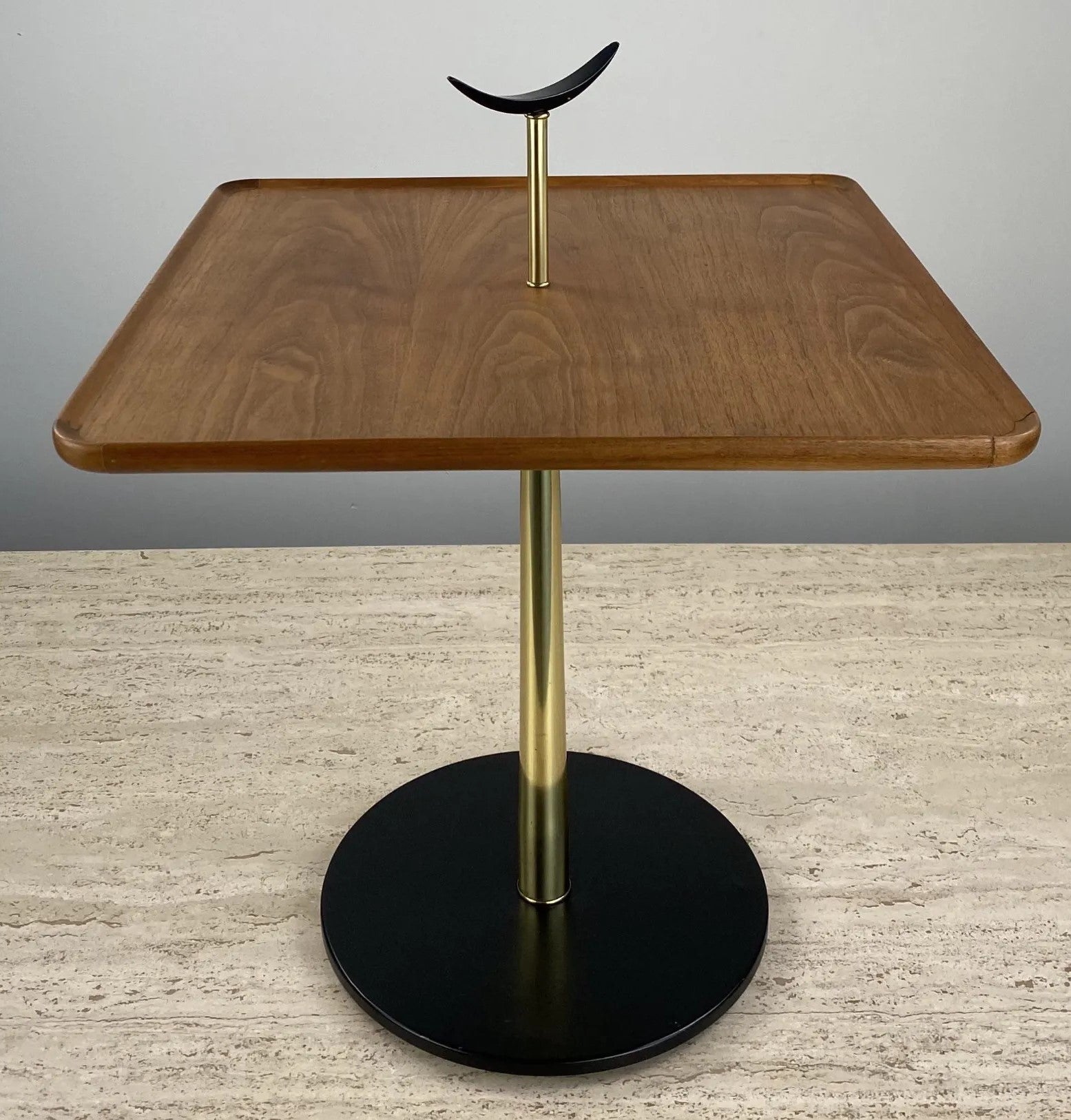 Milo Baughman for Arch Gordon side table. The table has an enameled crescent shaped handle, a walnut square top, brass stem and a black enameled metal round base. 
Measures: 23.5