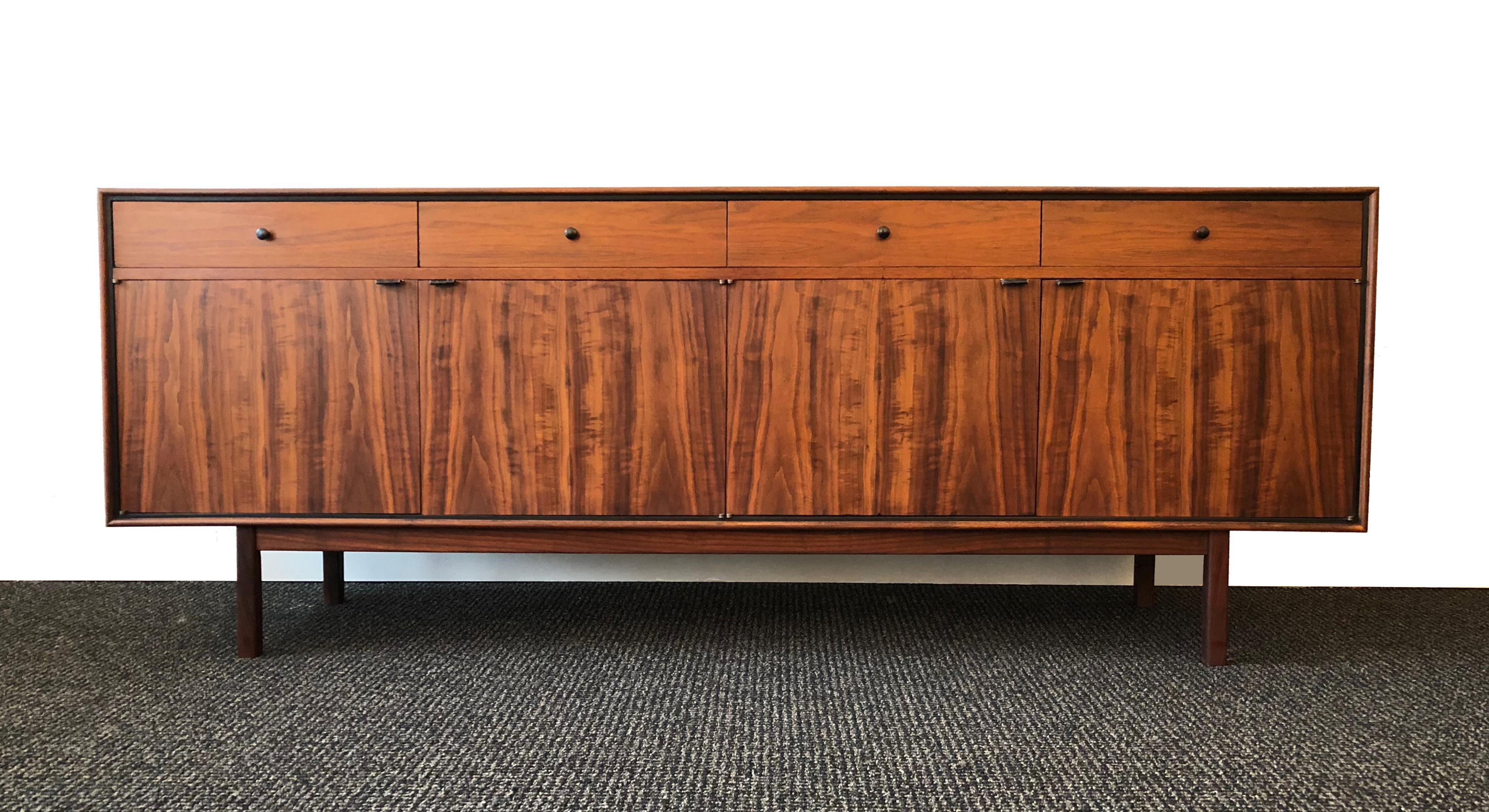 A beautifully-grained Mid-Century Modern credenza by Milo Baughman for Arch Gordon, 1950s.

The walnut cabinet and drawers handsomely contrast with the rosewood doors and base, offset by ebonized black detail and original black leather door pulls.