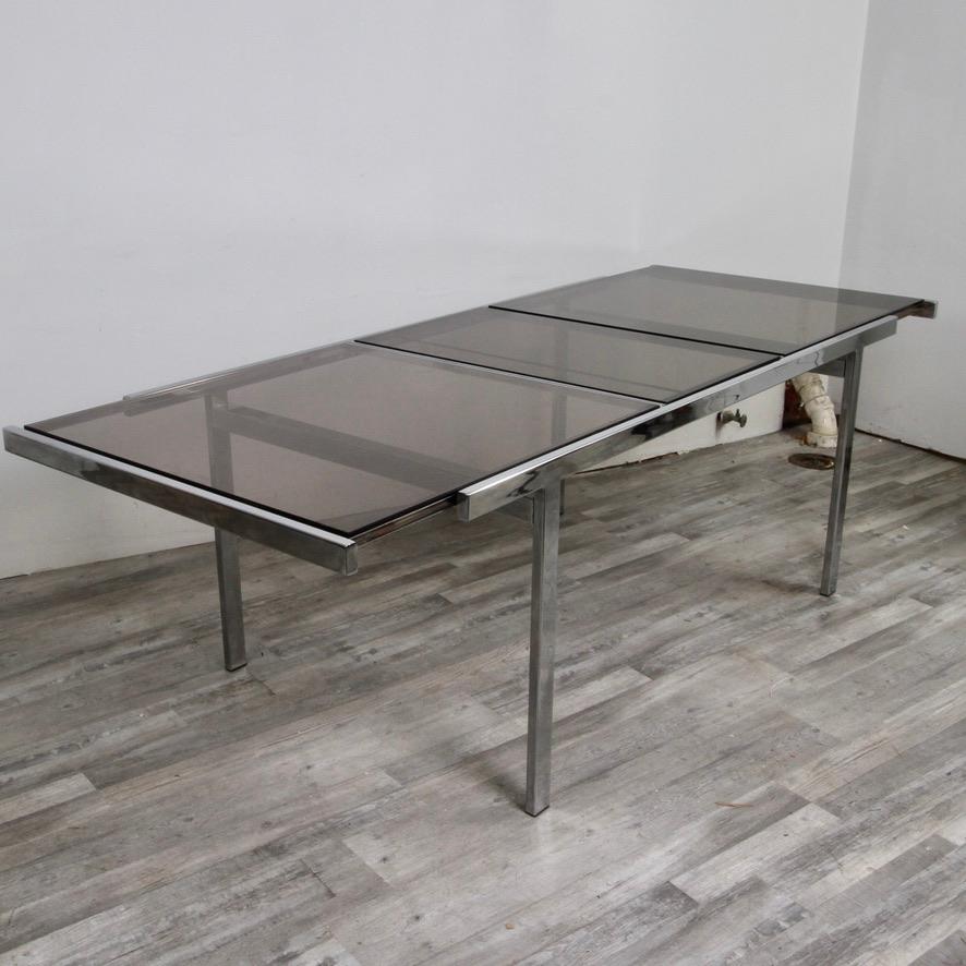 Extendable chrome dining table by DIA, made of smoked glass and chrome with hidden leaf. table opens up to 95.5