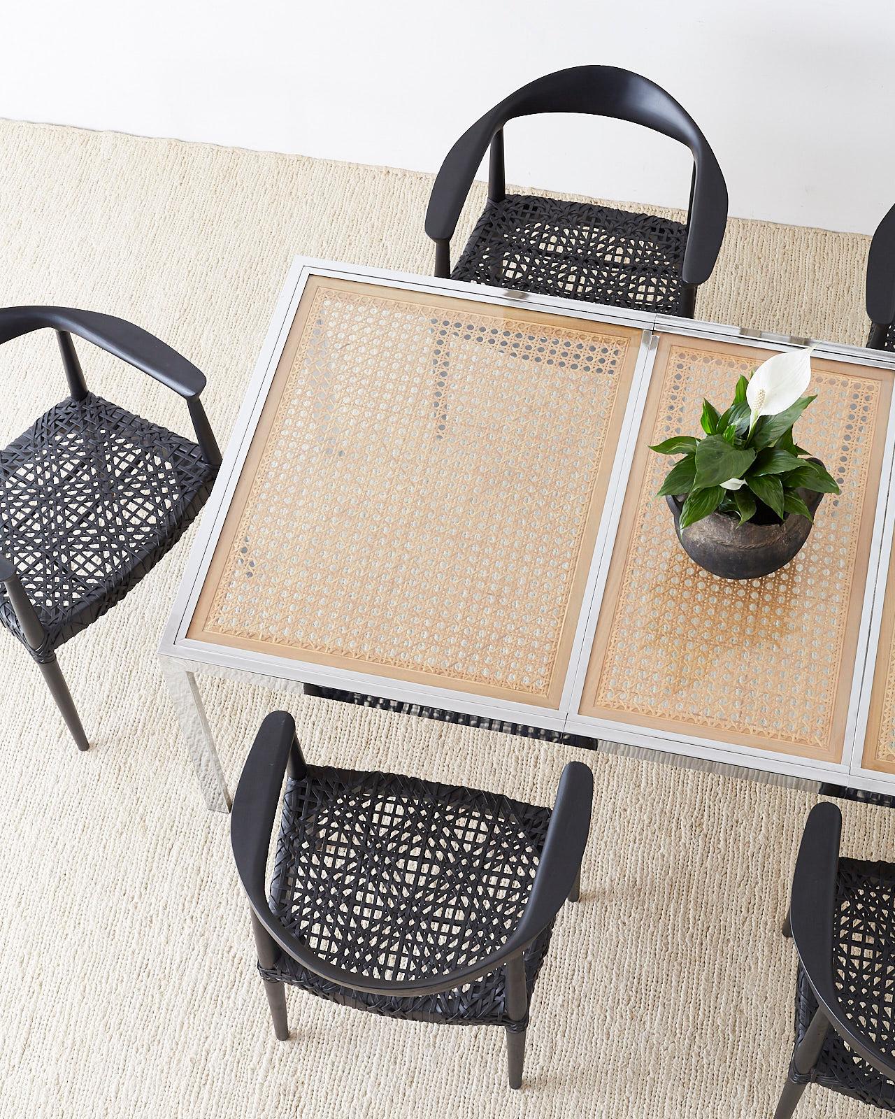 Mid-Century Modern chrome dining table featuring a glass covered cane wicker inset. Designed by Milo Baughman this rare table has a leaf that extends it from 60 inches wide to 80 inches. Simple parson's style leg with a shiny finish. Beautifully