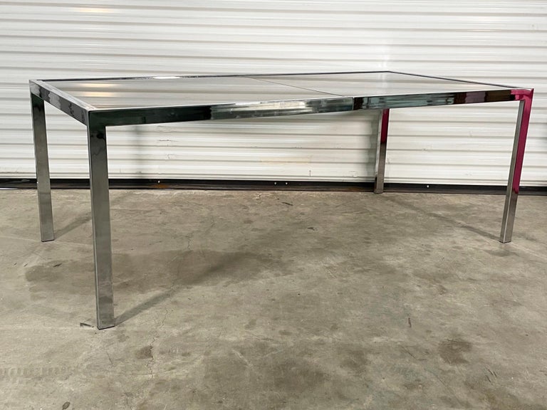 Mid century chrome dining table by Design Institute of America features smoked glass and expands to 96