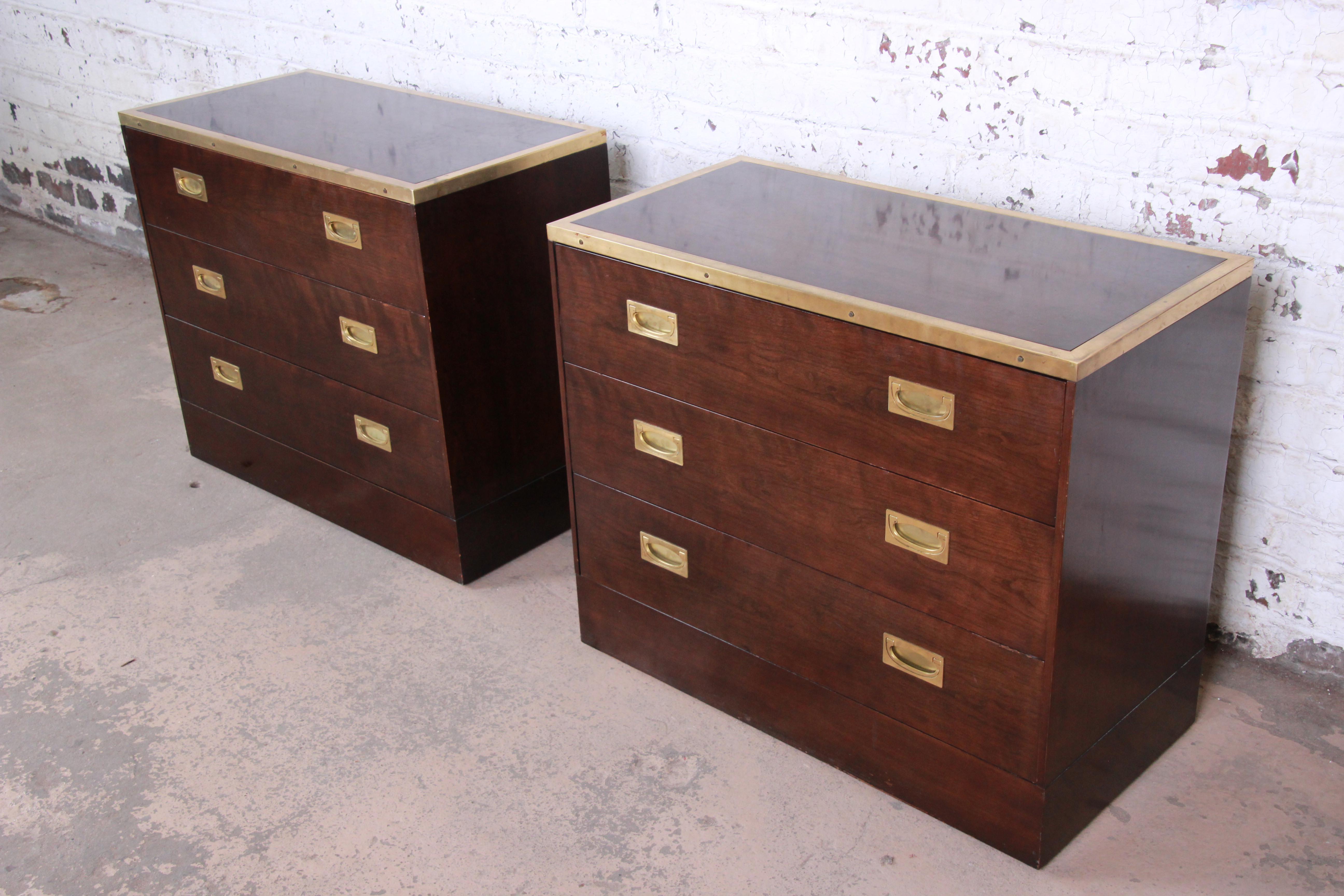 A gorgeous pair of Mid-Century Modern Hollywood Regency Campaign style nightstands or bachelor chests by Milo Baughman for the exclusive Custom Collection for Directional. The chests feature rich wood grain with elegant brass trim and original brass