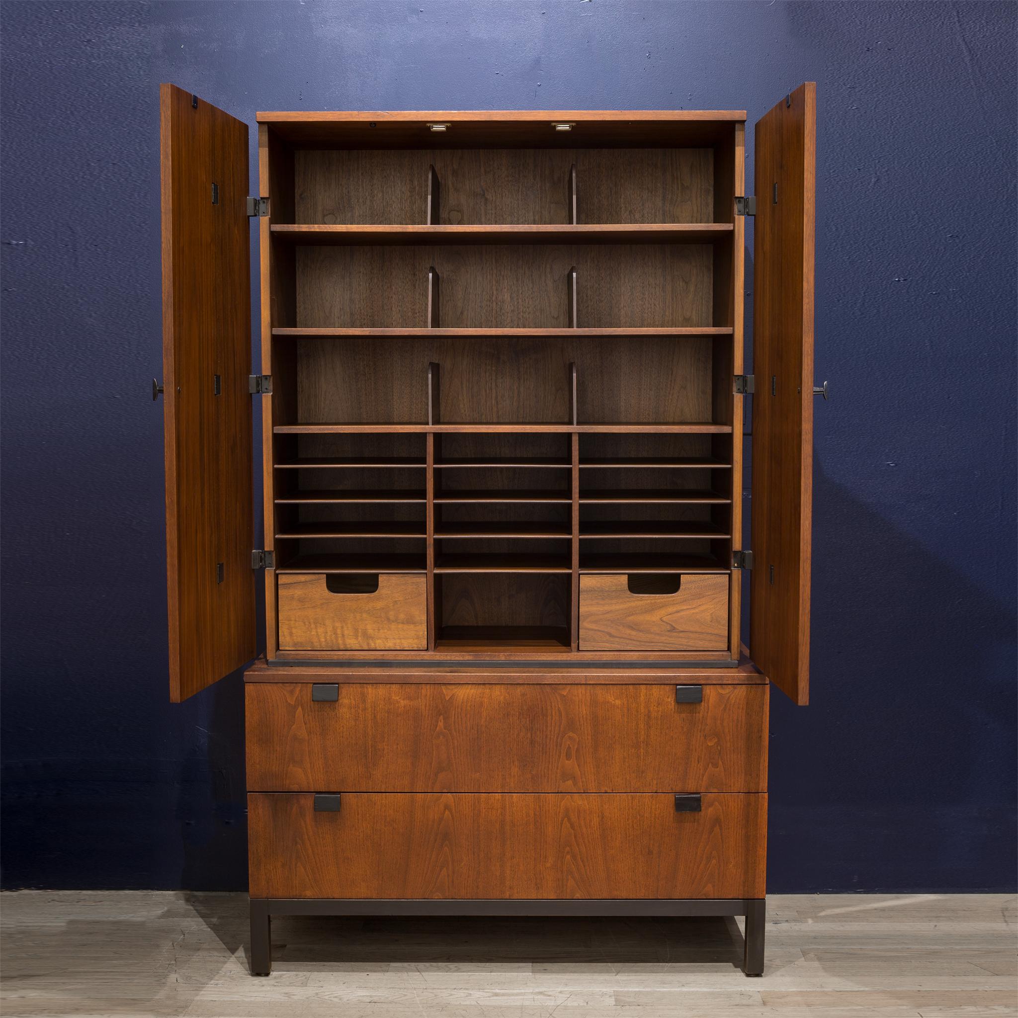 About:

A midcentury walnut gentleman's chest designed by Milo Baughman for Directional. The two-piece cabinet features Walnut wood grain and sculptural ebonized pulls and hinges, and the entire cabinet rests on a base with ebonized legs and trim.