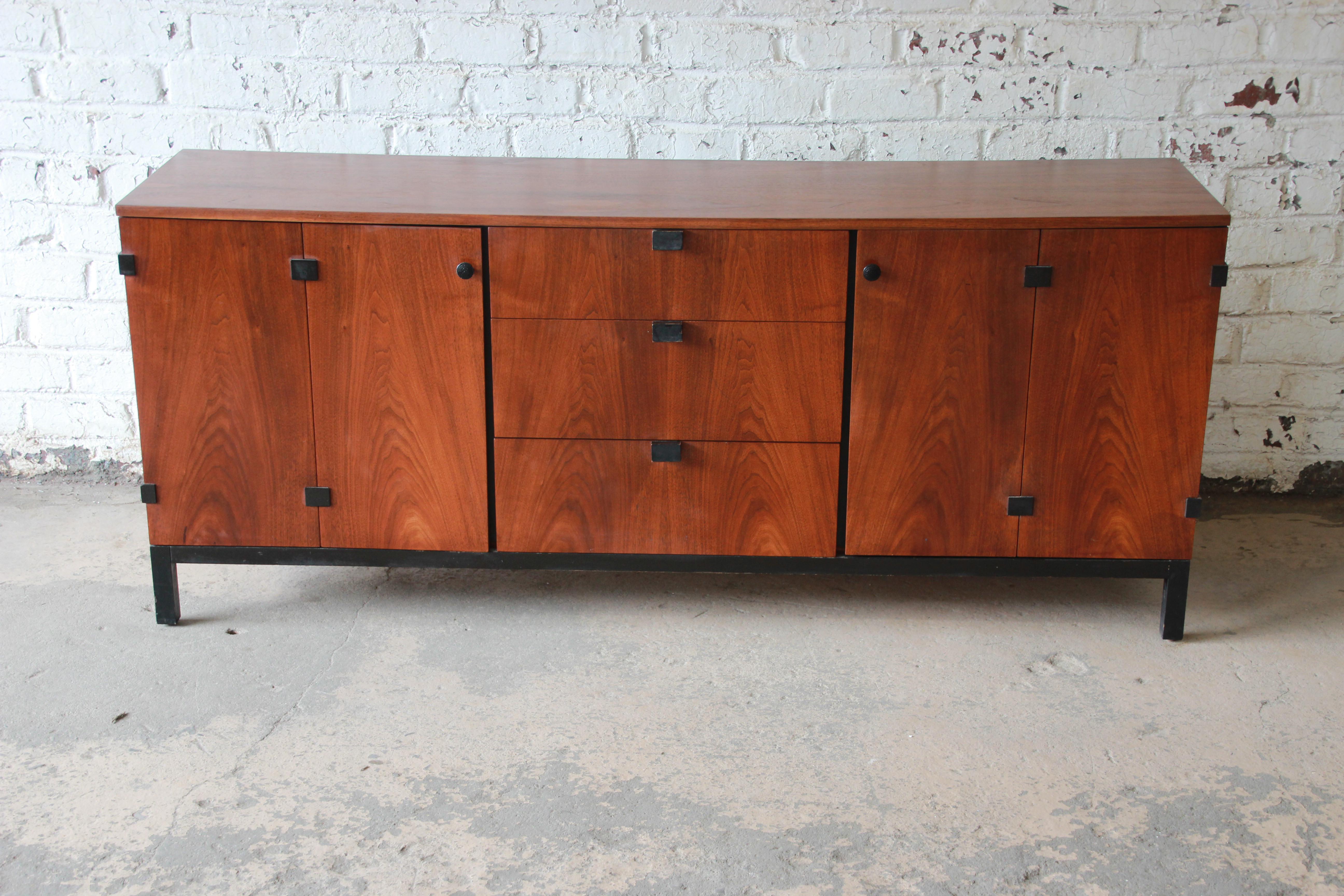 Offering a stunning Mid-Century Modern walnut nine-drawer credenza or triple dresser designed by Milo Baughman for Directional circa 1960s. The credenza features gorgeous book-matched walnut wood grain, with sculpted ebonized pulls and an ebonized