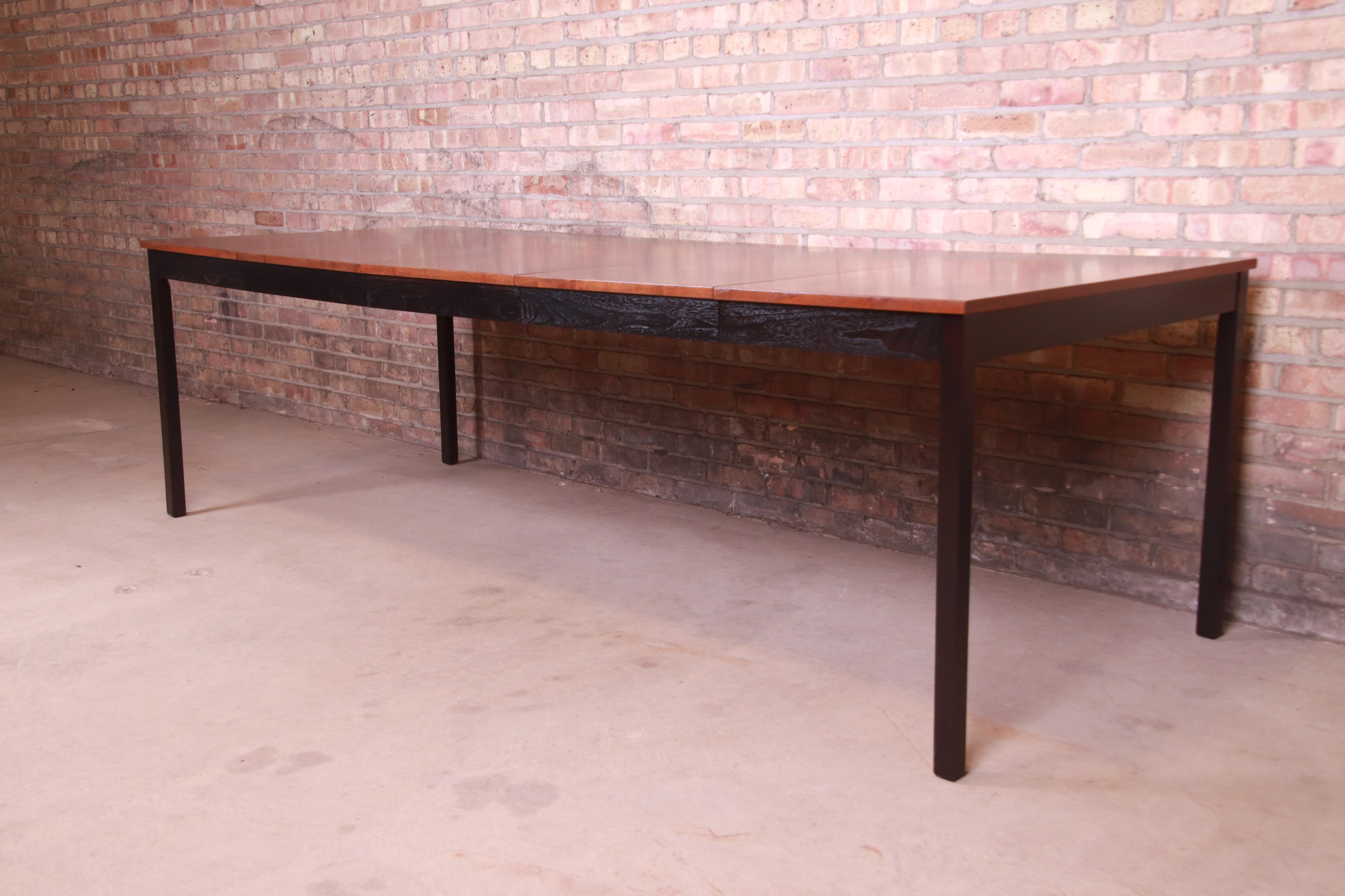 An exceptional Mid-Century Modern extension dining table

By Milo Baughman

USA, 1960s

Walnut, with ebonized trim and legs.

Measures: 38