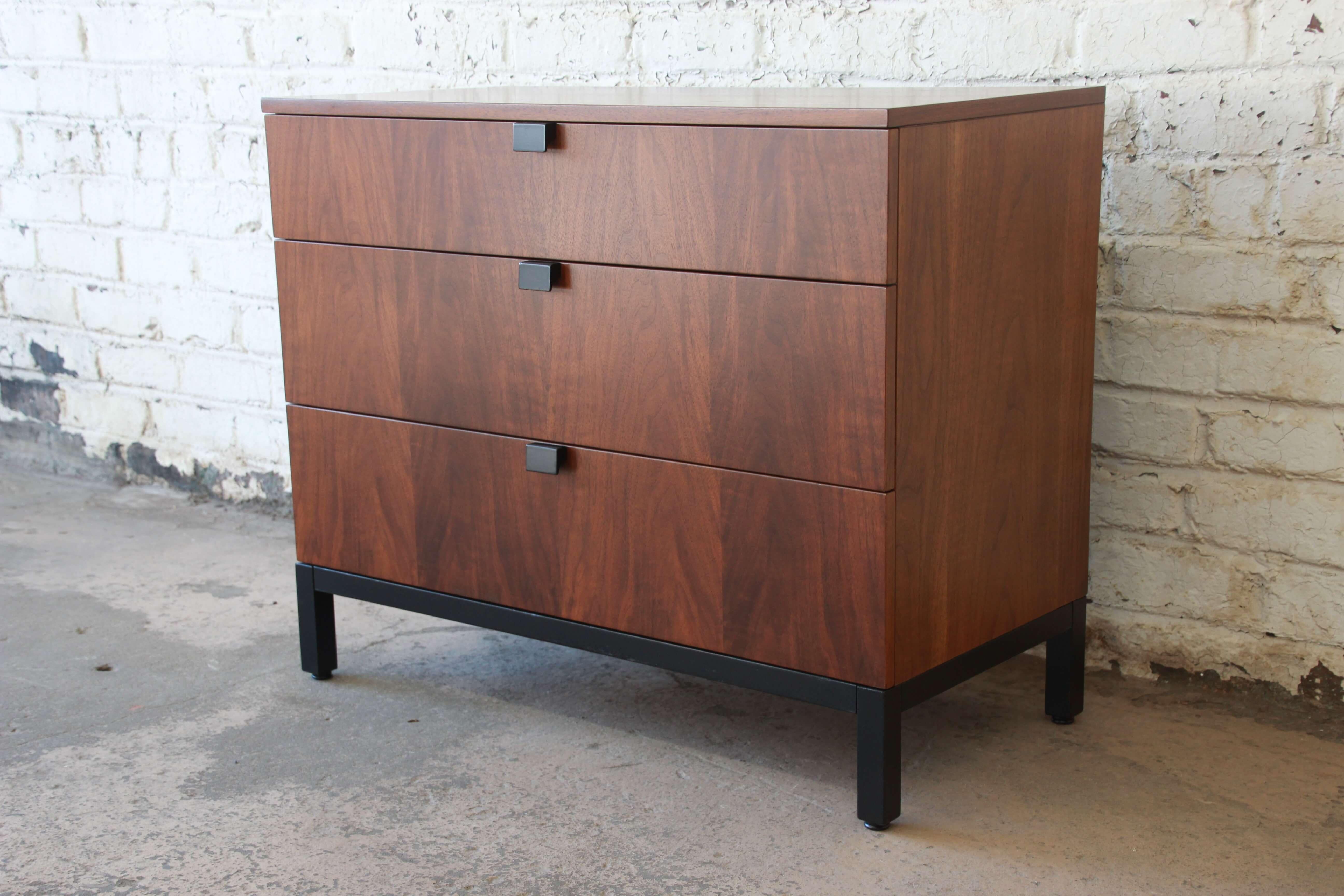 Offering an excellent bachelor chest or large nightstand by Milo Baughman for directional. The chest has a very nice walnut wood grain and three large drawers offering organization and plenty of storage. It is accented with a black lacquered base