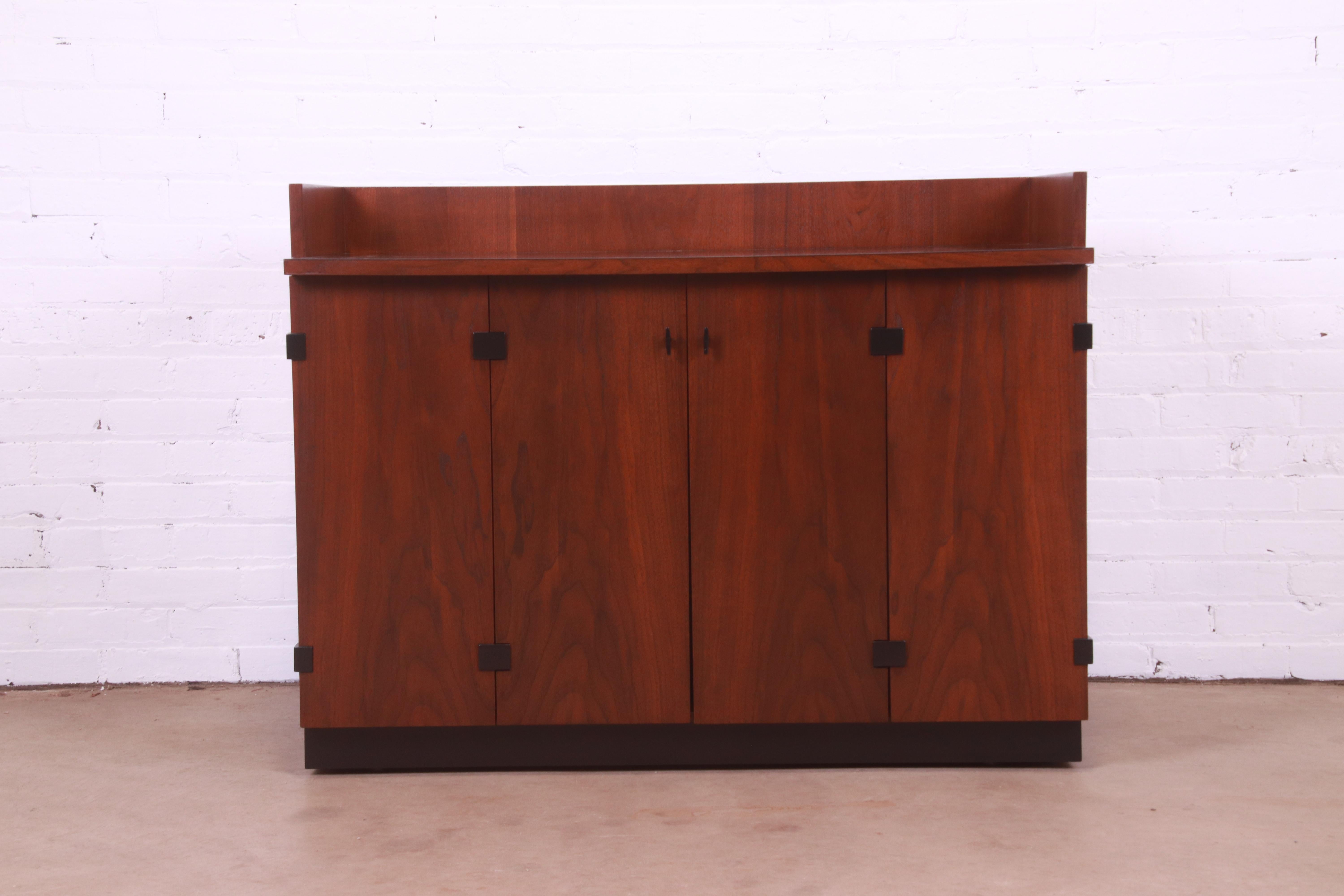 An exceptional Mid-Century Modern sideboard, buffet server, or bar cabinet

By Milo Baughman for Directional

USA, 1960s

Gorgeous book-matched walnut, with ebonized plinth base and accents, original hardware, and black laminate
