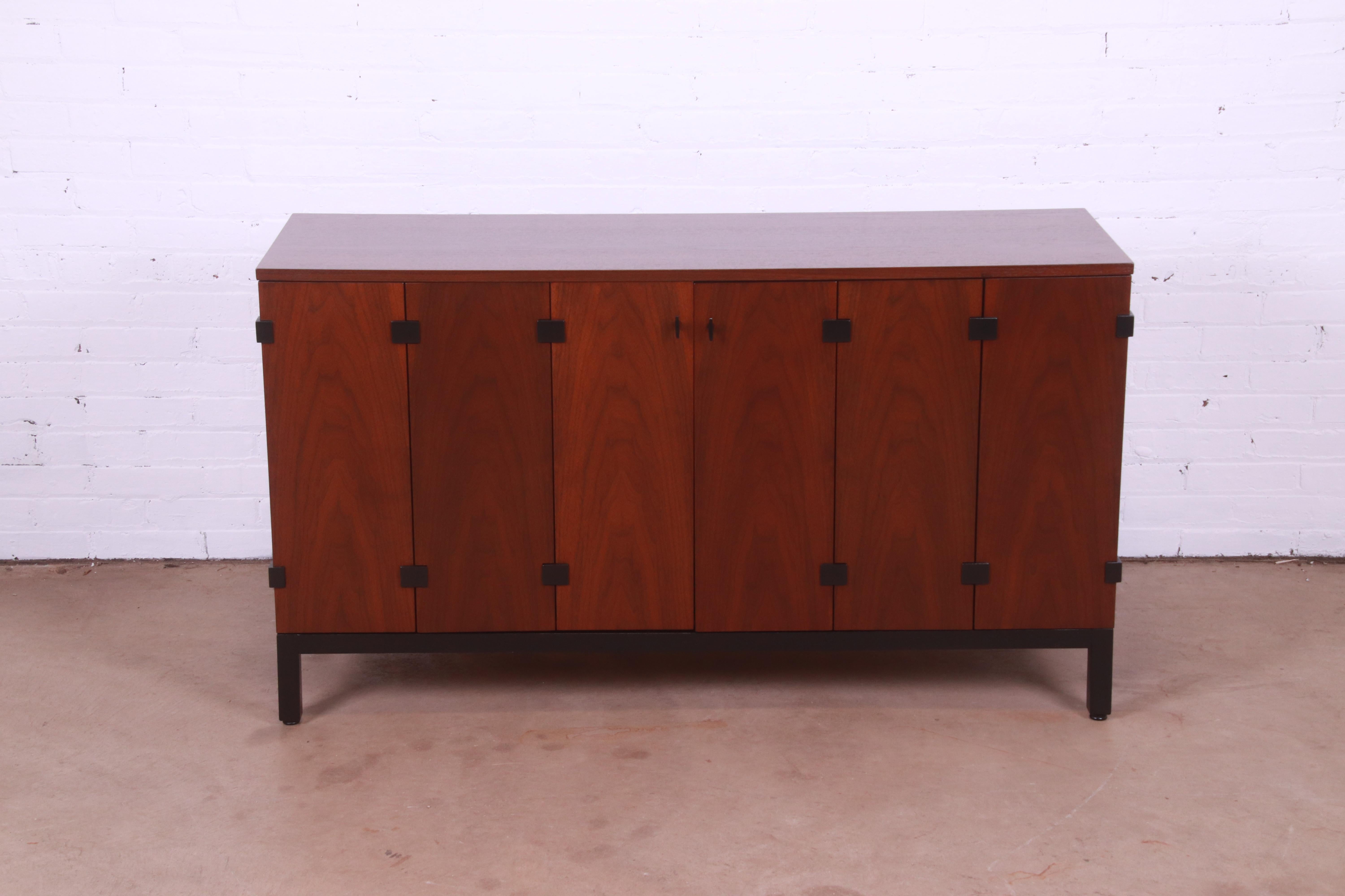 An exceptional mid-century modern sideboard, credenza, or bar cabinet

By Milo Baughman for Directional

USA, 1960s

Gorgeous book-matched walnut, with ebonized legs and accents and original hardware.

Measures: 54