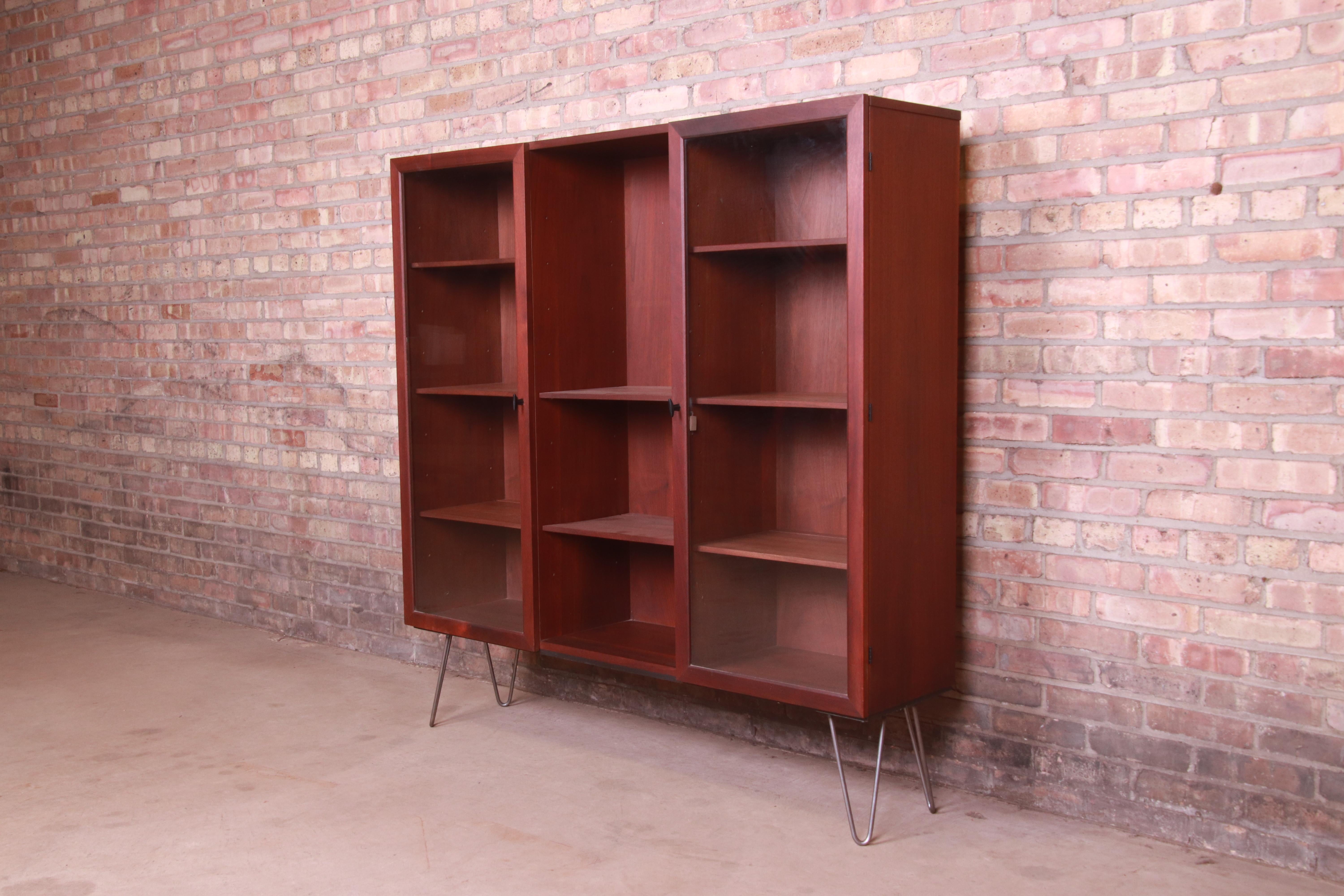 A sleek and stylish Mid-Century Modern display cabinet or bookcase

By Milo Baughman for Directional

USA, 1960s

Walnut, with glass front doors and steel hairpin legs.

Measures: 54