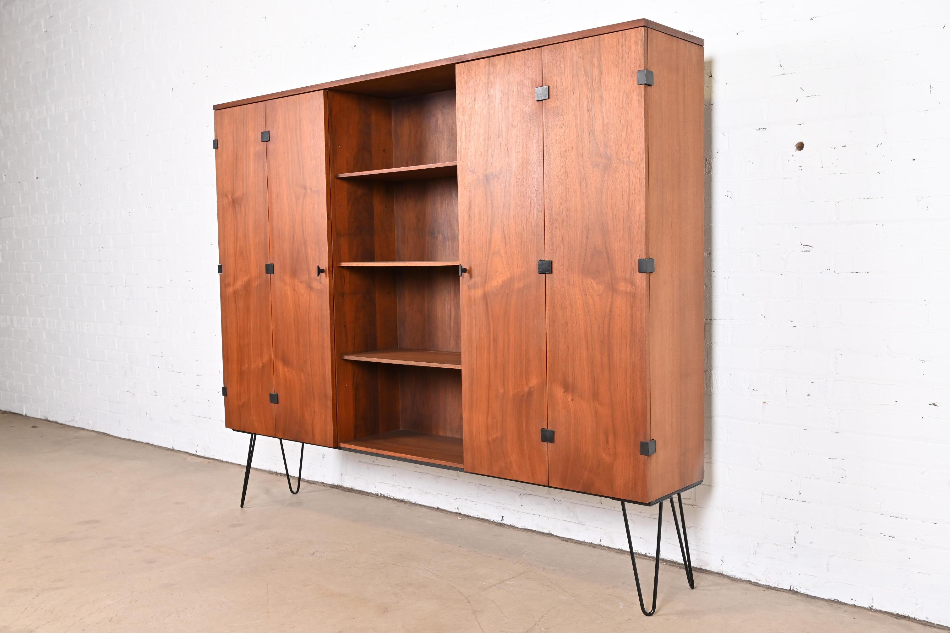 A sleek and stylish Mid-Century Modern display cabinet, bar cabinet, or bookcase

By Milo Baughman for Directional

USA, 1960s

Walnut, with ebonized accents and steel hairpin legs.

Measures: 72.38