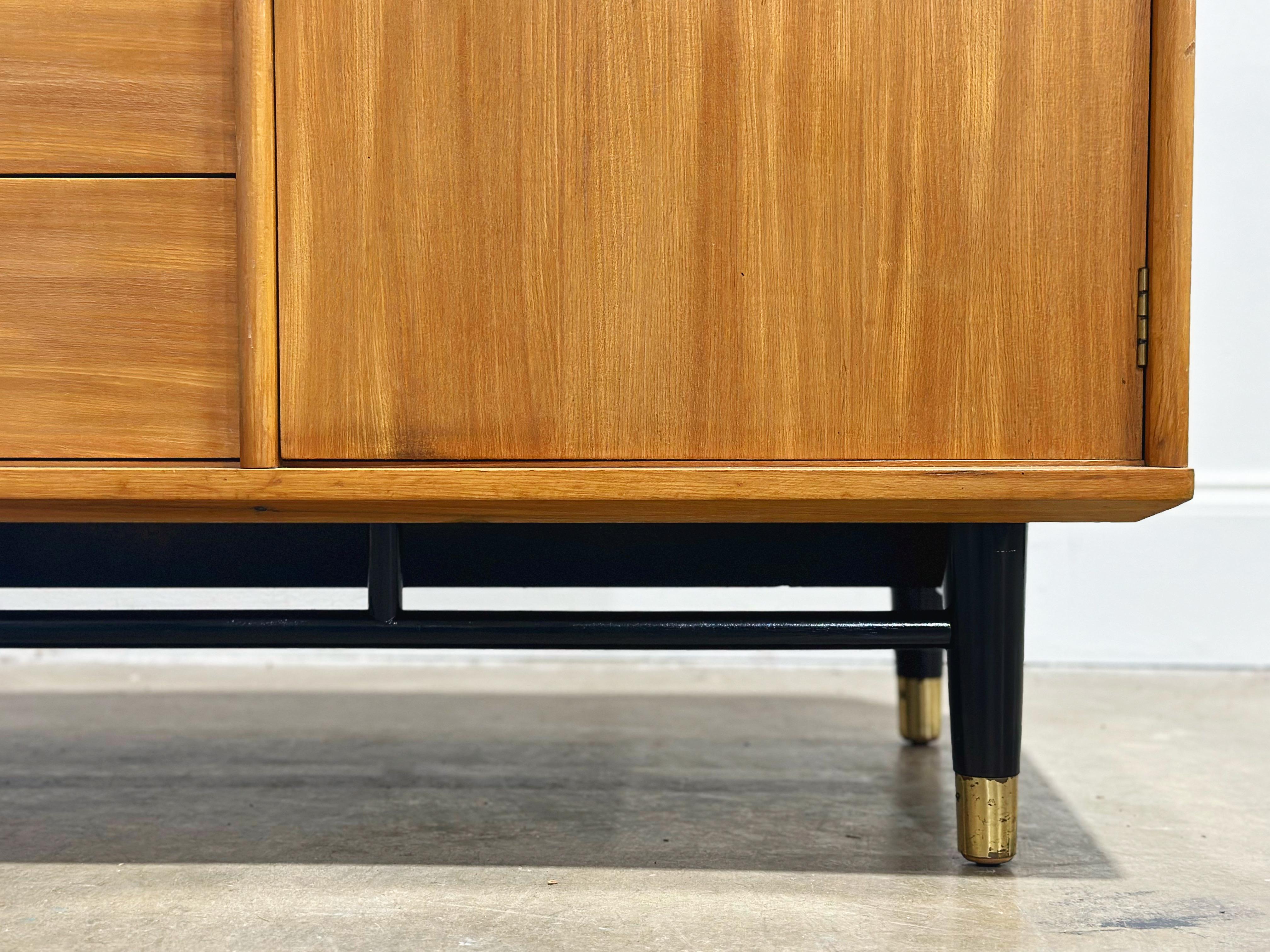 Stellar midcentury modern credenza by Milo Baughman for Drexel, Today's Living line. Solid elm construction with a black lacquered base, solid brass 