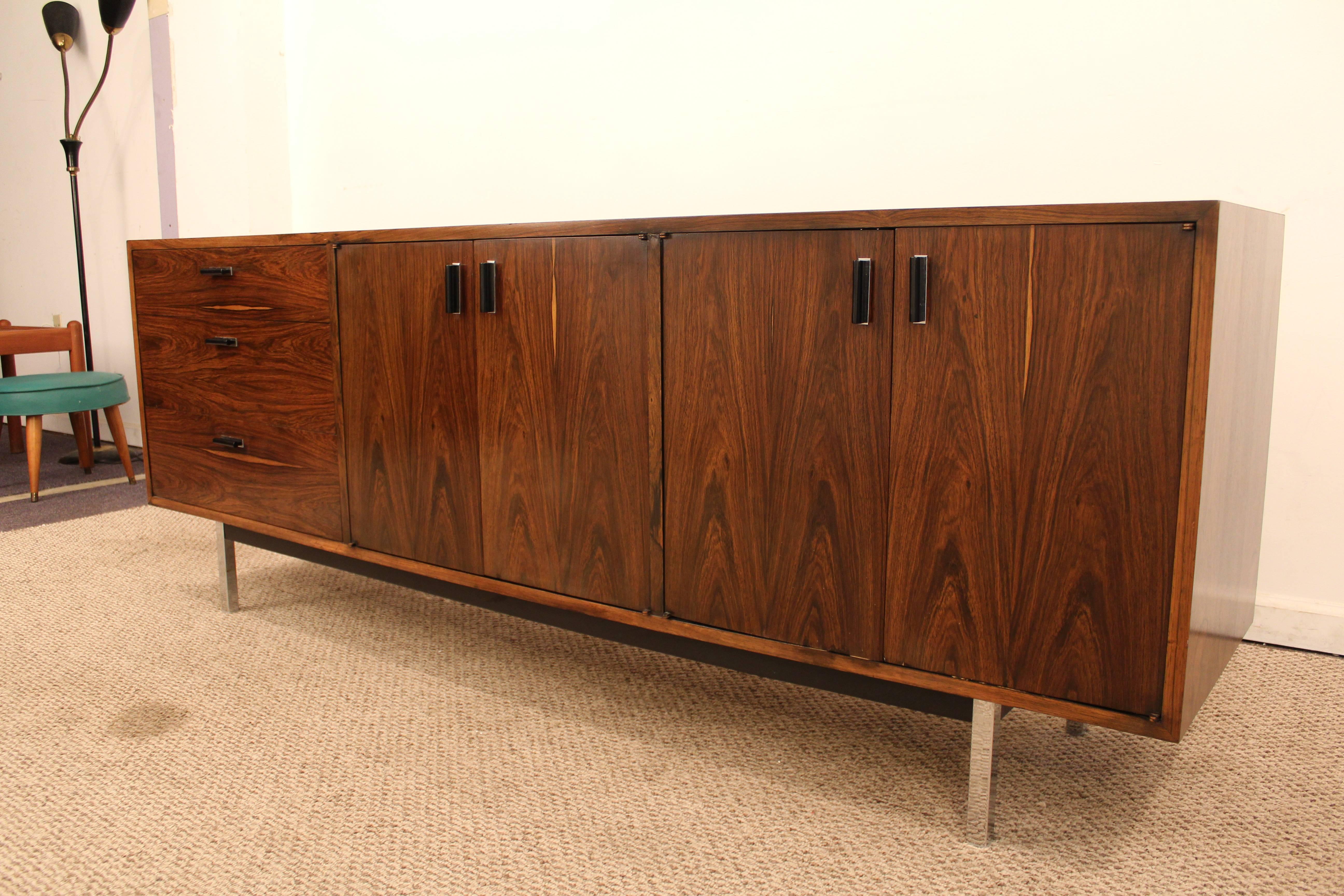 Offered is a beautiful midcentury Danish modern rosewood or chrome Milo Baughman Founders credenza. It is made with rosewood and chrome. Has three drawers one side and doors with shelving inside. It is signed by Founders.