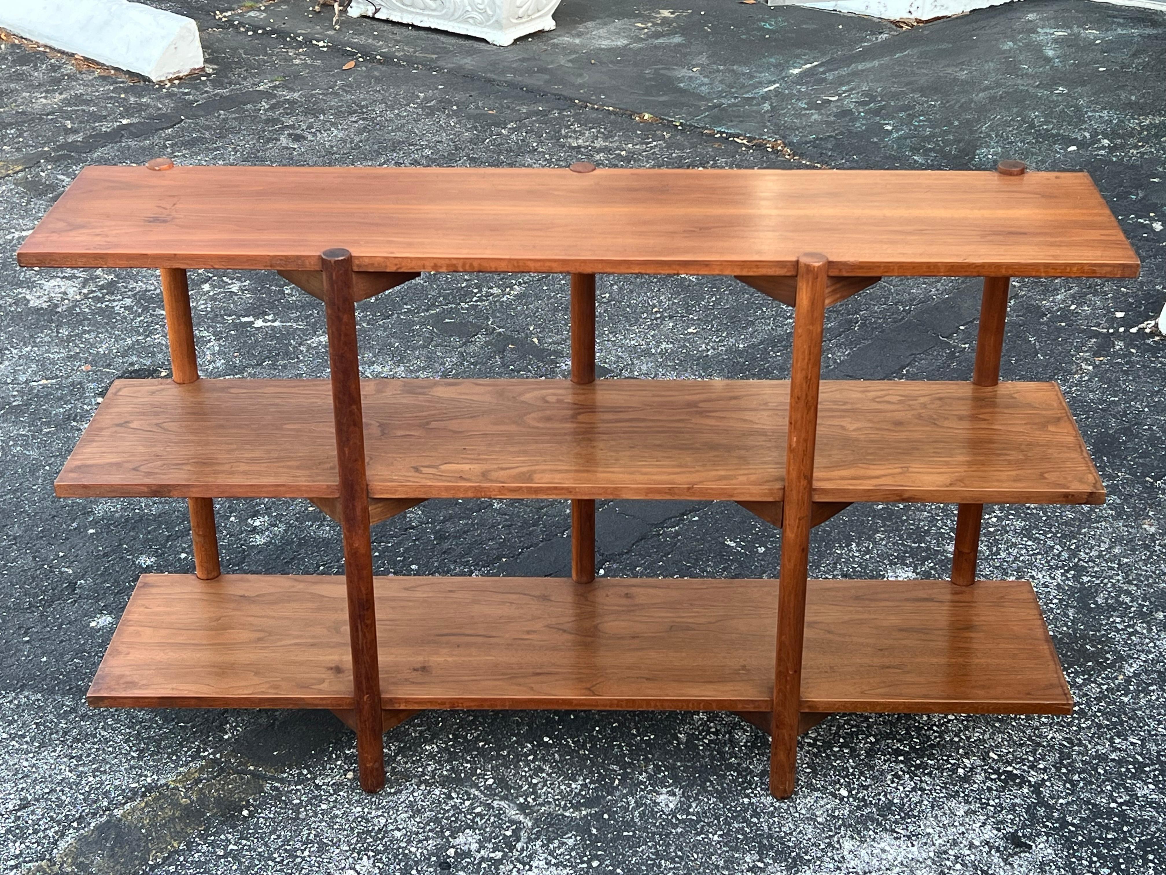 A classic Milo Baughman for Glenn of California three tier bookshelf or open bookcase. Unusual design with five legs and supporting brackets. Made of walnut with nice patina, ca' 1950's.