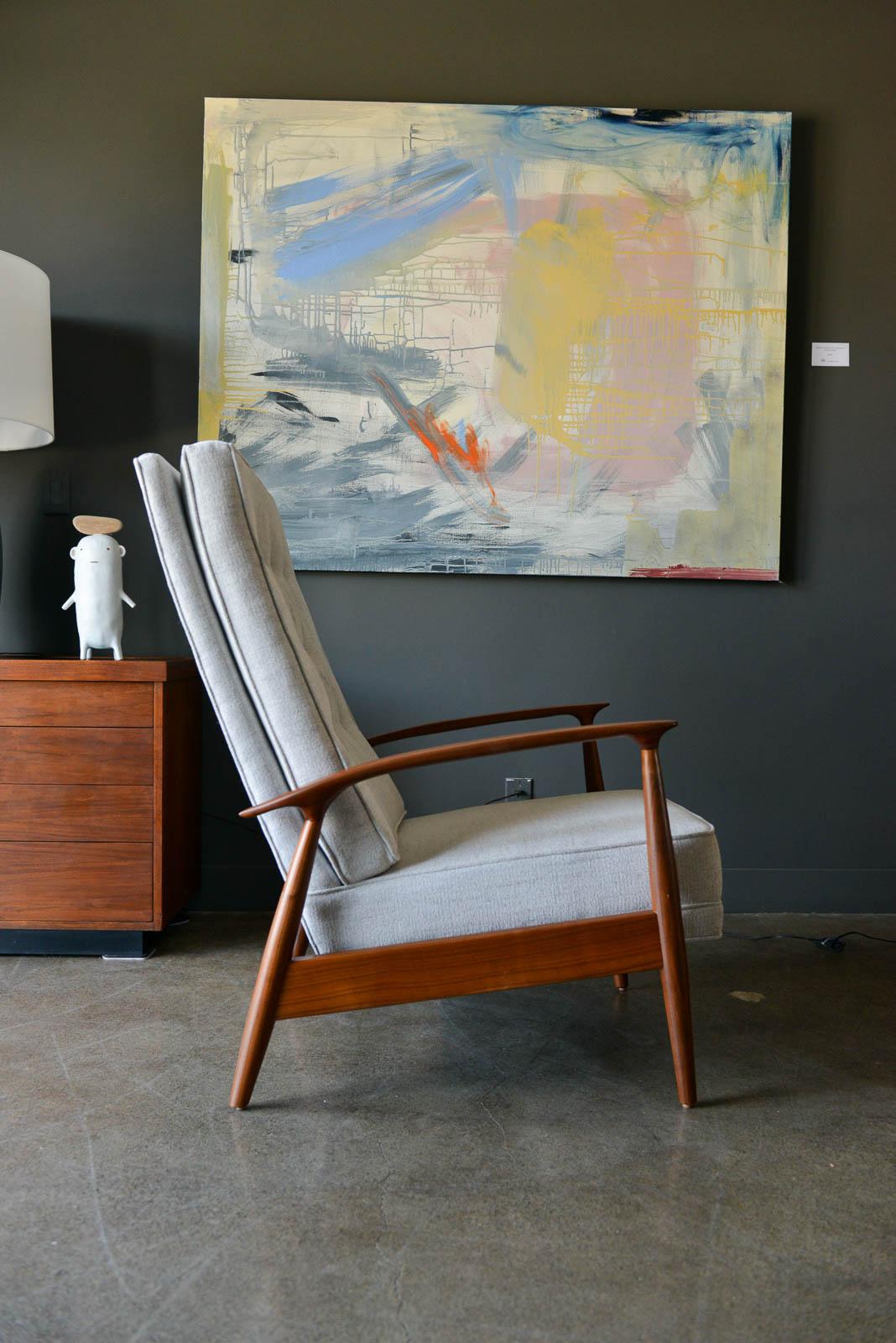 Milo Baughman for James, Inc. sculpted walnut reclining lounge chair, circa 1955. Professionally restored walnut frame with new light grey textured fabric and tufted button back. Reclining mechanism hides underneath chair when not in use and is