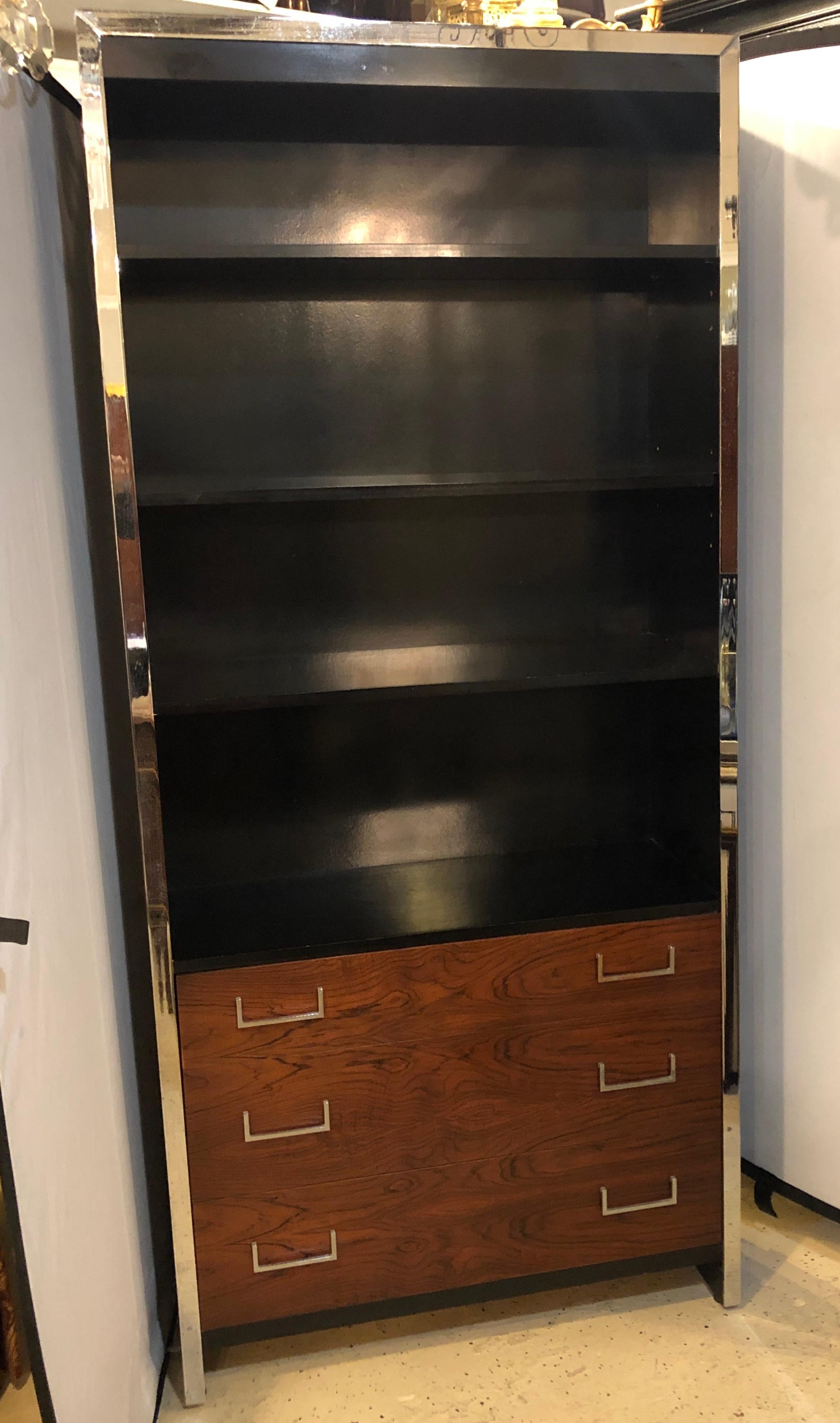 A West Michigan Furniture Mid-Century Modern bookcase over commode having an ebony case and rosewood drawer fronts with chrome frame and drawer pulls. Distributed by John Stuart, bearing the label on the interior of one drawer.