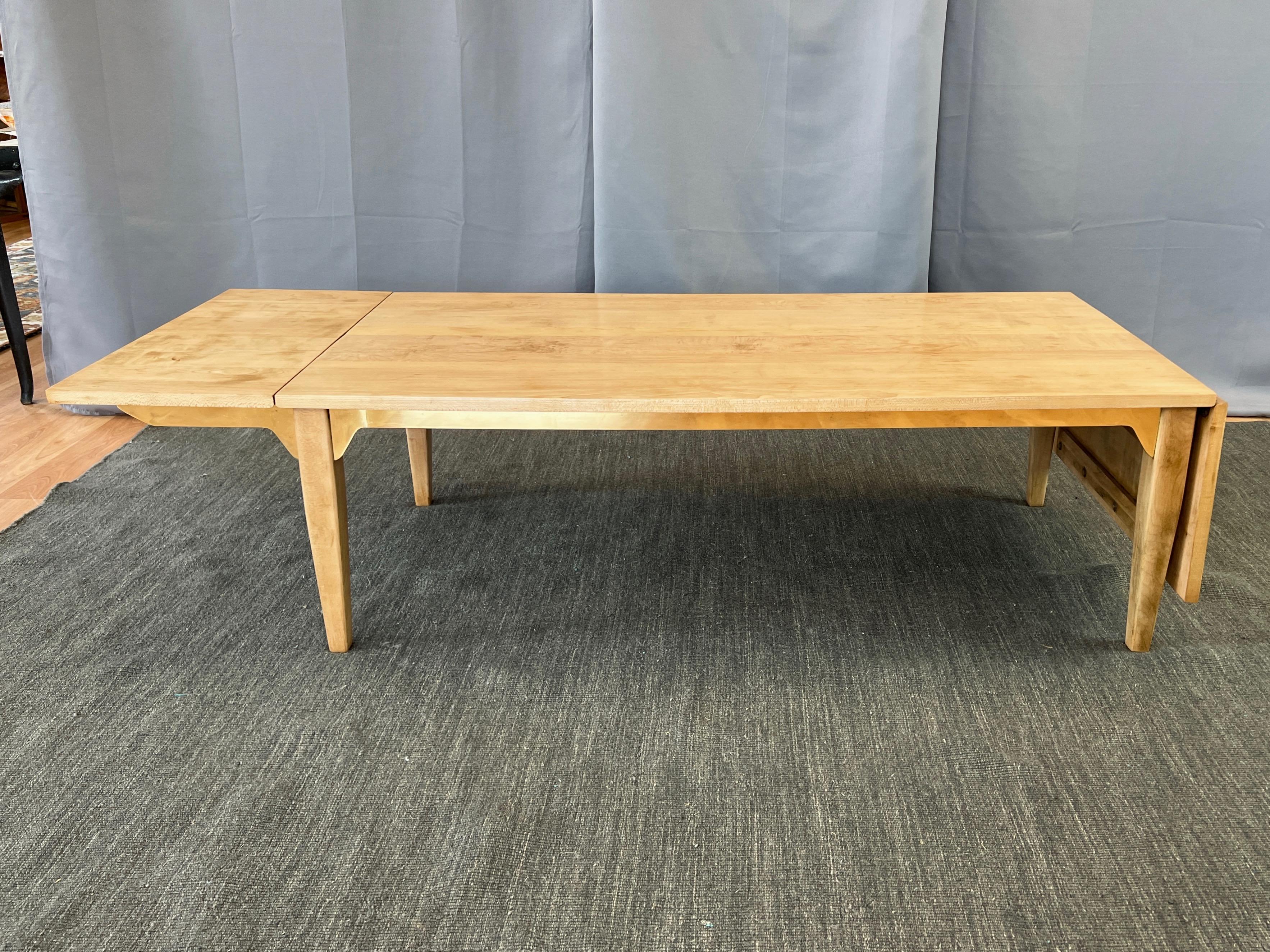A rare 1953 birch and brass drop-leaf coffee table by Milo Baughman for Murray Furniture.

Solid birch construction with dynamic figuring throughout, especially notable on a top section. Features gleaming blade-like brass aprons and swing-out