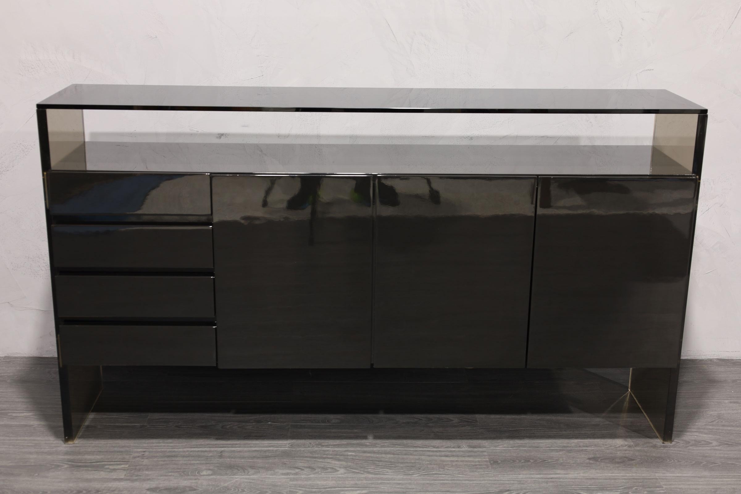 One of his iconic designs, a restored in black lacquer sideboard by Milo Baughman. Sideboard features a floating case piece that includes three doors with shelving and silverware storage. On the left side is four felt lined drawers. The thick Lucite