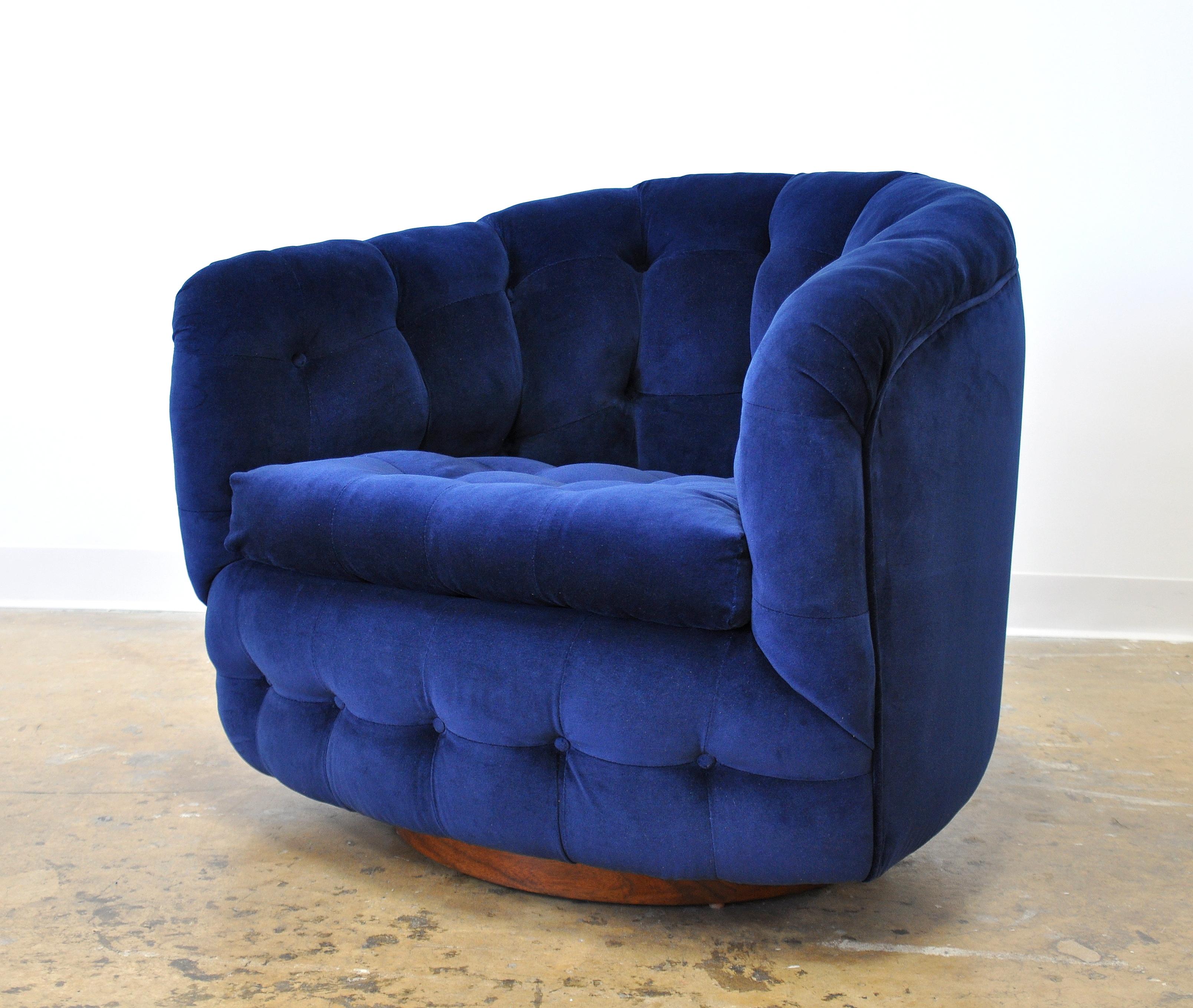 A fabulous Mid-Century Modern tufted barrel back swiveling and rocking club chair, designed by Milo Baughman for Thayer Coggin, and dating from the 1960s. Fully restored and reupholstered in a luxurious and rich sapphire navy blue jewel tone velvet;
