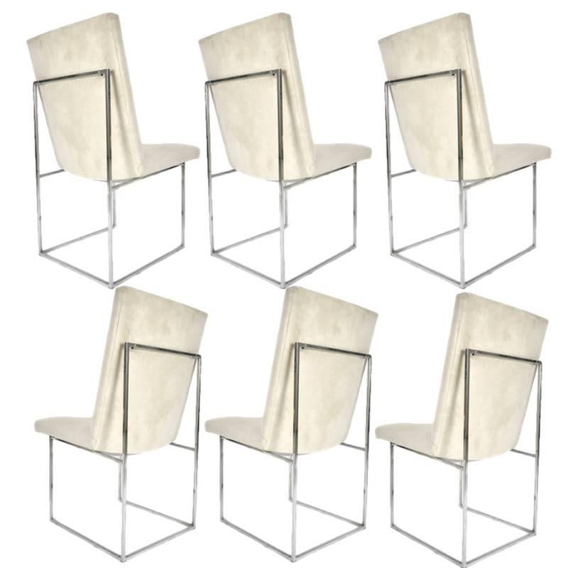 One of Milo Baughman's more iconic designs. These dining chairs have a stunning architectural base of polished chrome square stock metal supporting a floating seat and back. Upholstered in off-white original ultra-suede.