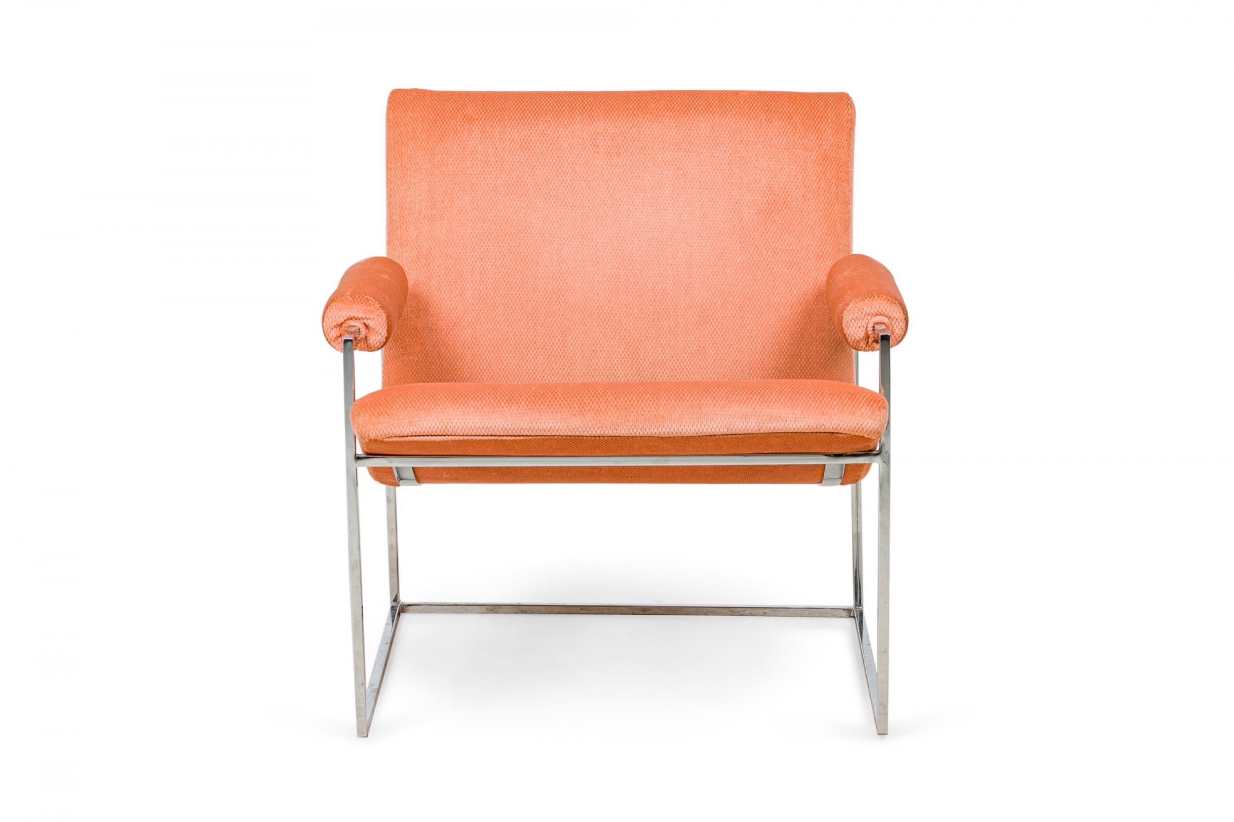 American Mid-Century scoop armchair with light pink coral textured velour upholstered seat, back, and arms with button tufted detail along the seam where the seat and back join, supported by a thin square tube chrome frame and legs. (MILO BAUGHMAN