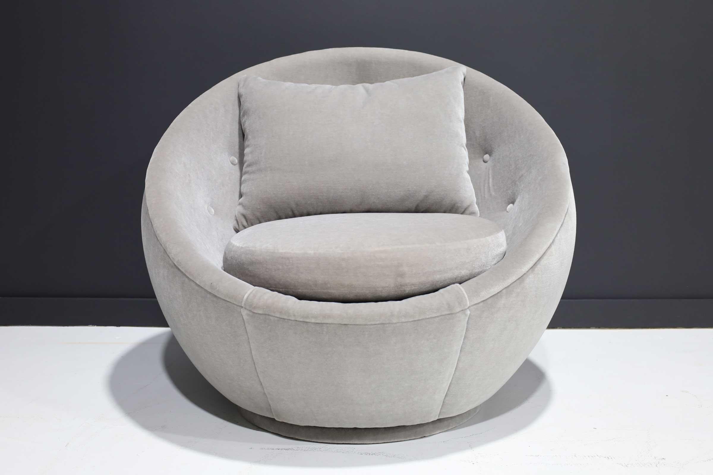 An iconic Milo Baughman egg chair in light gray mohair. Has a walnut swivel base.