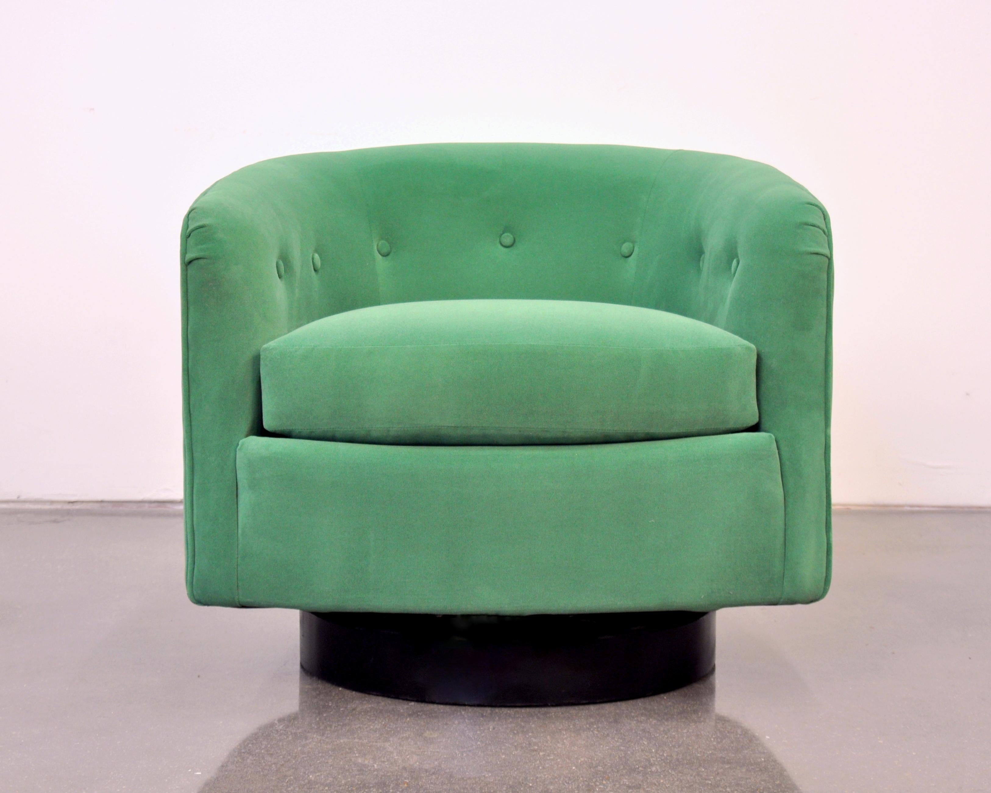 A 1960s vintage Mid-Century Modern tufted barrel back club or tub chair. The armchair has been fully restored and reupholstered in a gorgeous sage moss jewel tone green velvet. It features a round wood base with black finish and swiveling mechanism.