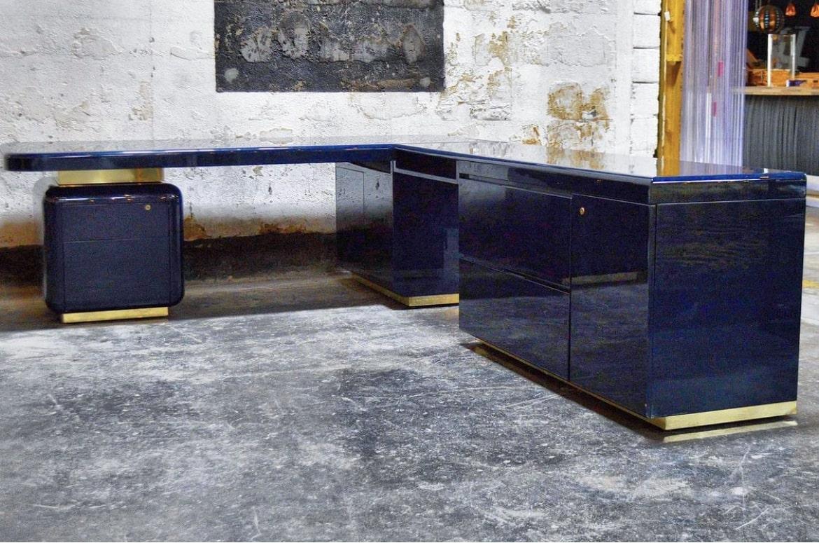 Milo Baughman Navy Lacquered Executive Corner Desk on brass plinth base. Navy high-gloss finish. Desk has multiple storage options, including two large filing drawers, two small filing drawers, three cabinets with shelving and an open drawer,