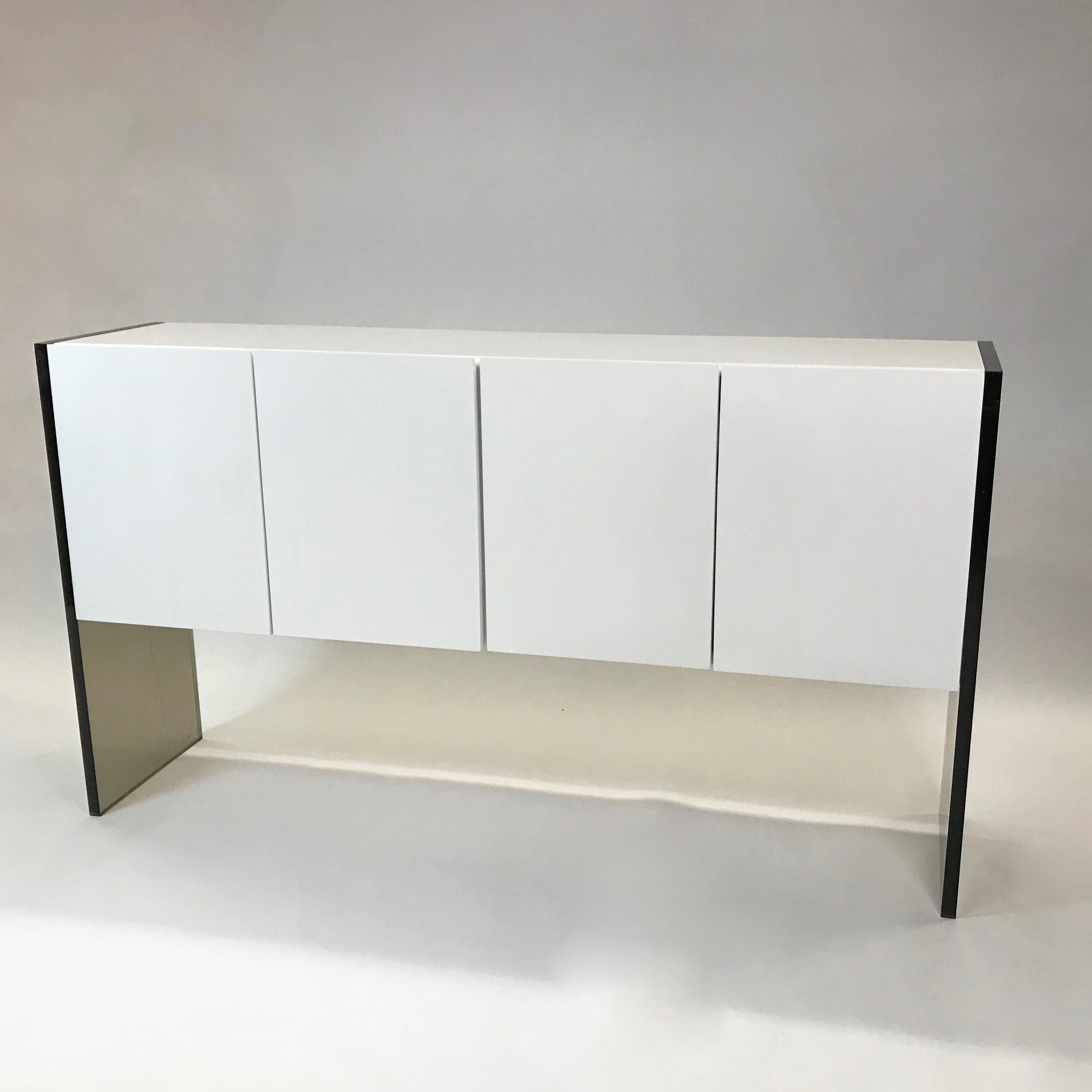 Minimal and chic, Mid-Century Modern, sideboard or credenza by Milo Baughman for Thayer Coggin features a clean white lacquered double cabinet with pull-out and smoked glass interior shelving contrasted by smoked Lucite side panels. The cabinet