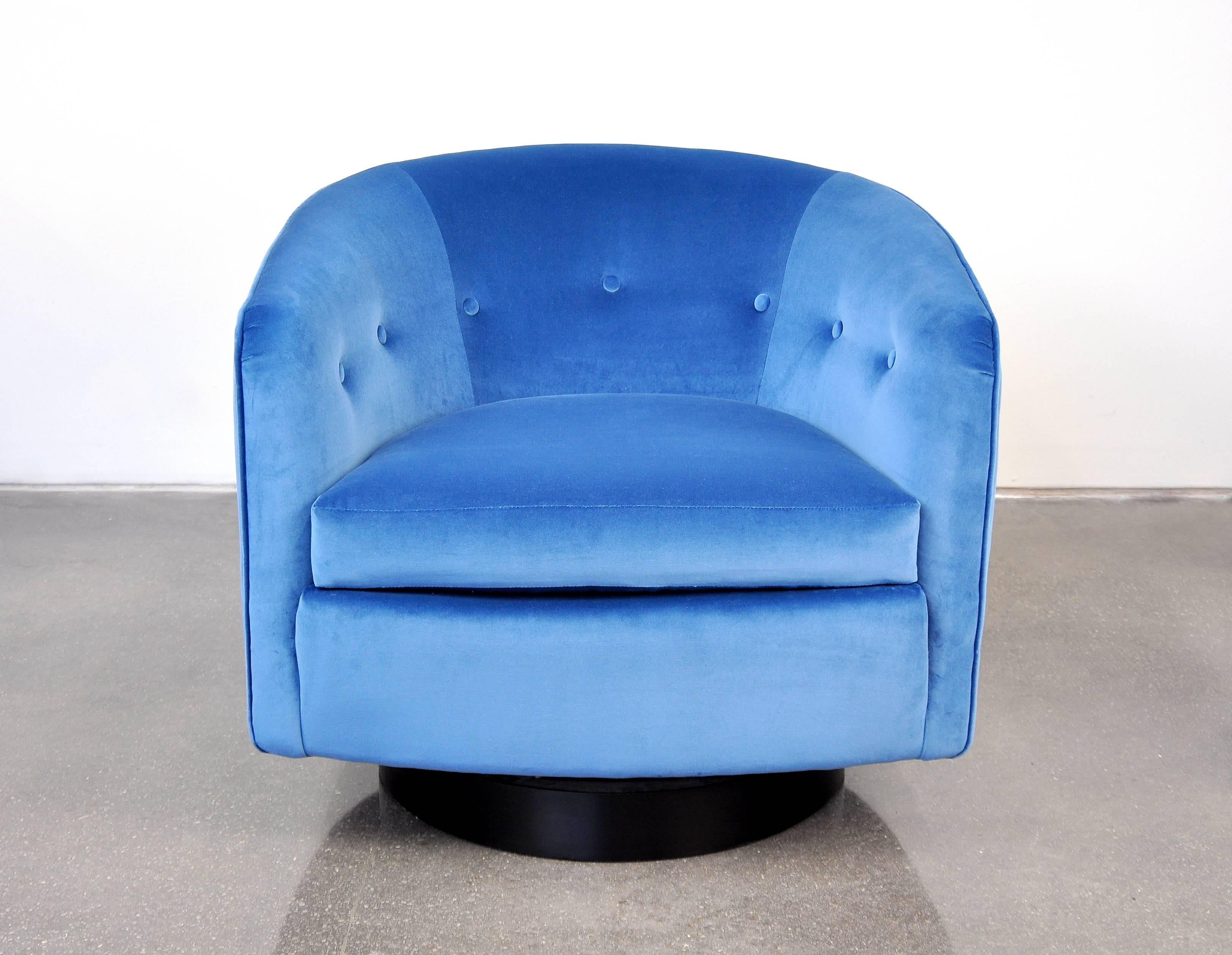 A vintage Mid-Century Modern barrel back club or tub chair, fully restored and reupholstered in a gorgeous pastel spring sky, sapphire blue velvet, featuring a round wood base with black finish and swivelling mechanism. A very comfortable armchair