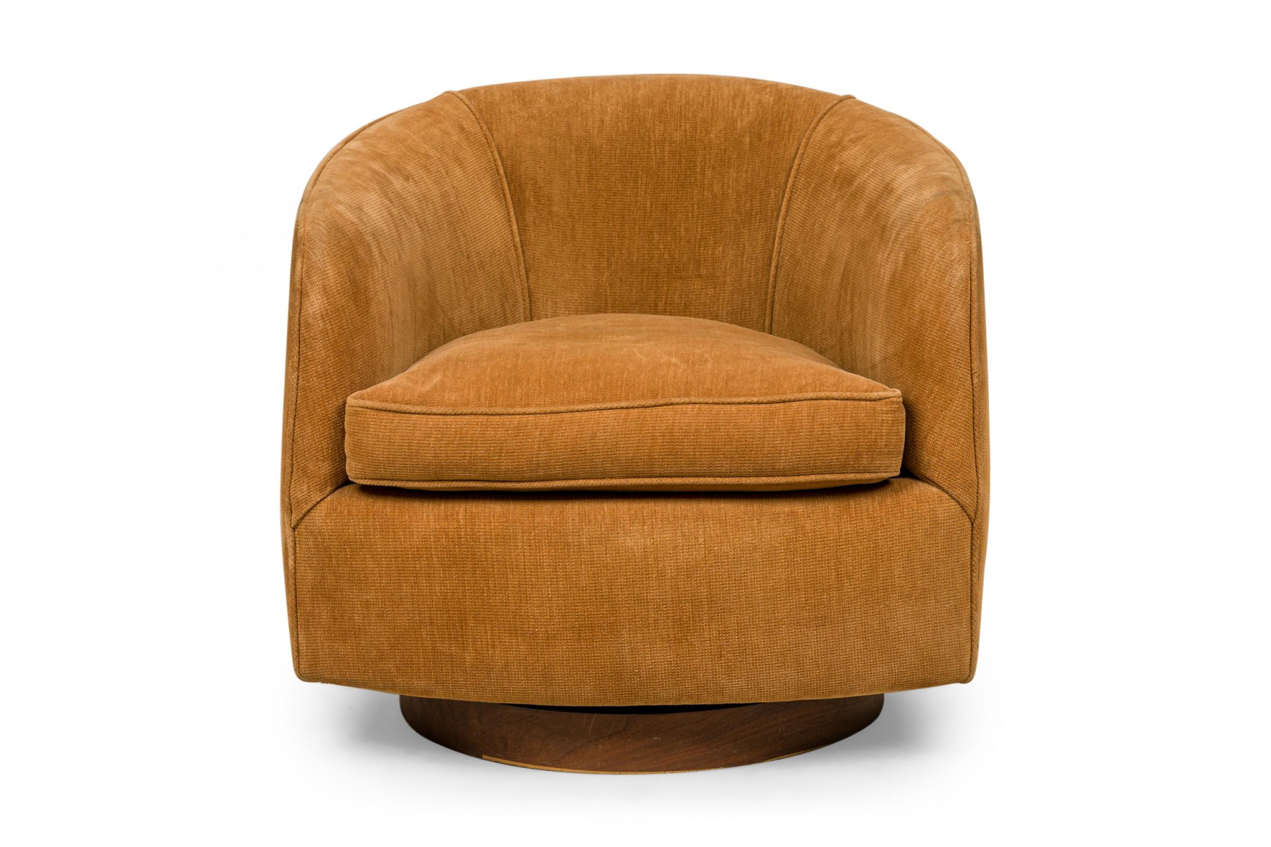 American Mid-Century horseshoe-form lounge / armchair upholstered in light brown velour, resting on a circular wood veneer plinth base. (MILO BAUGHMAN FOR THAYER COGGIN).
 